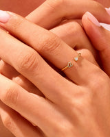 Gold initial ring with diamond accent on hand