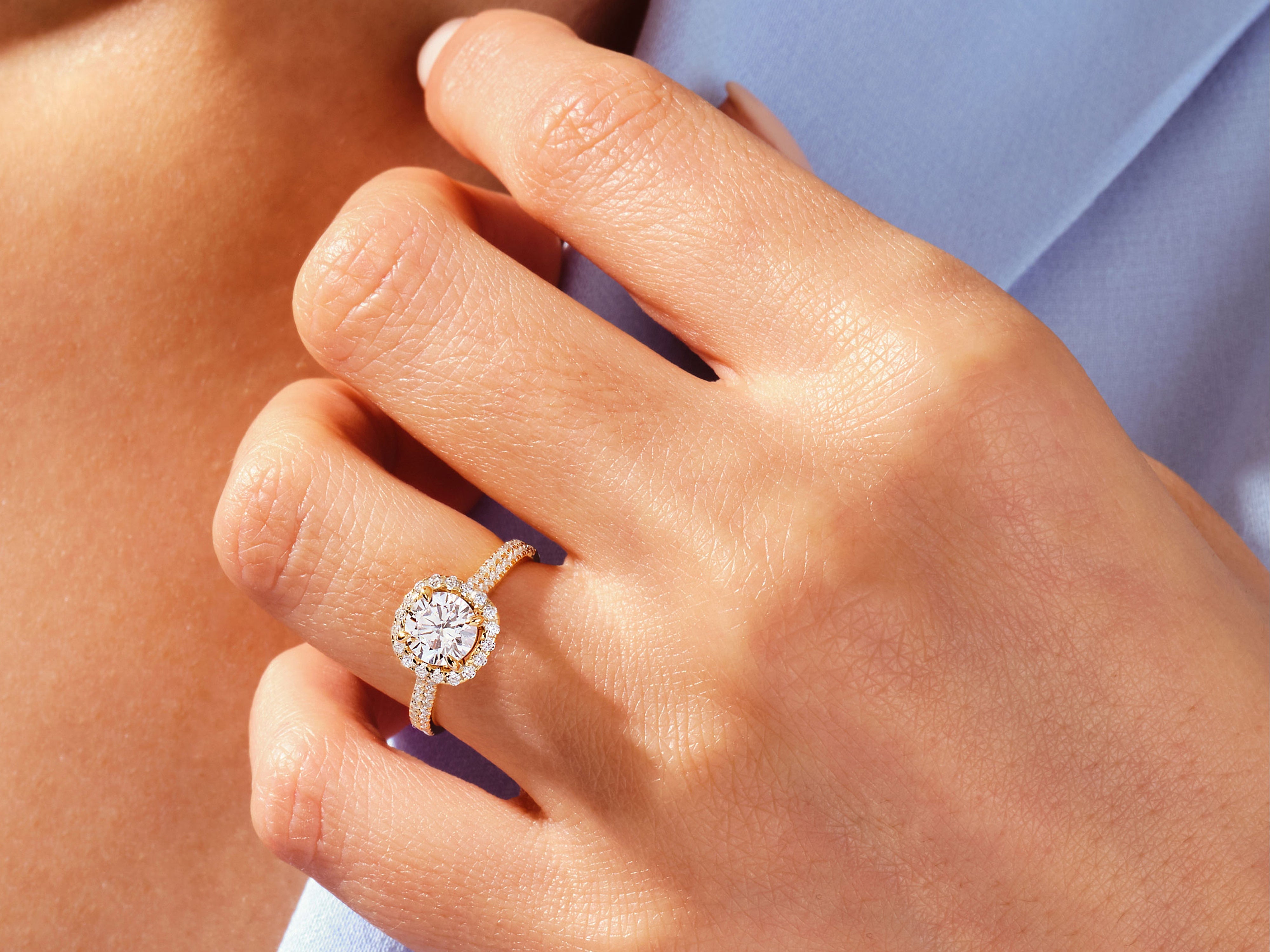 Diamond halo engagement ring on a woman's hand