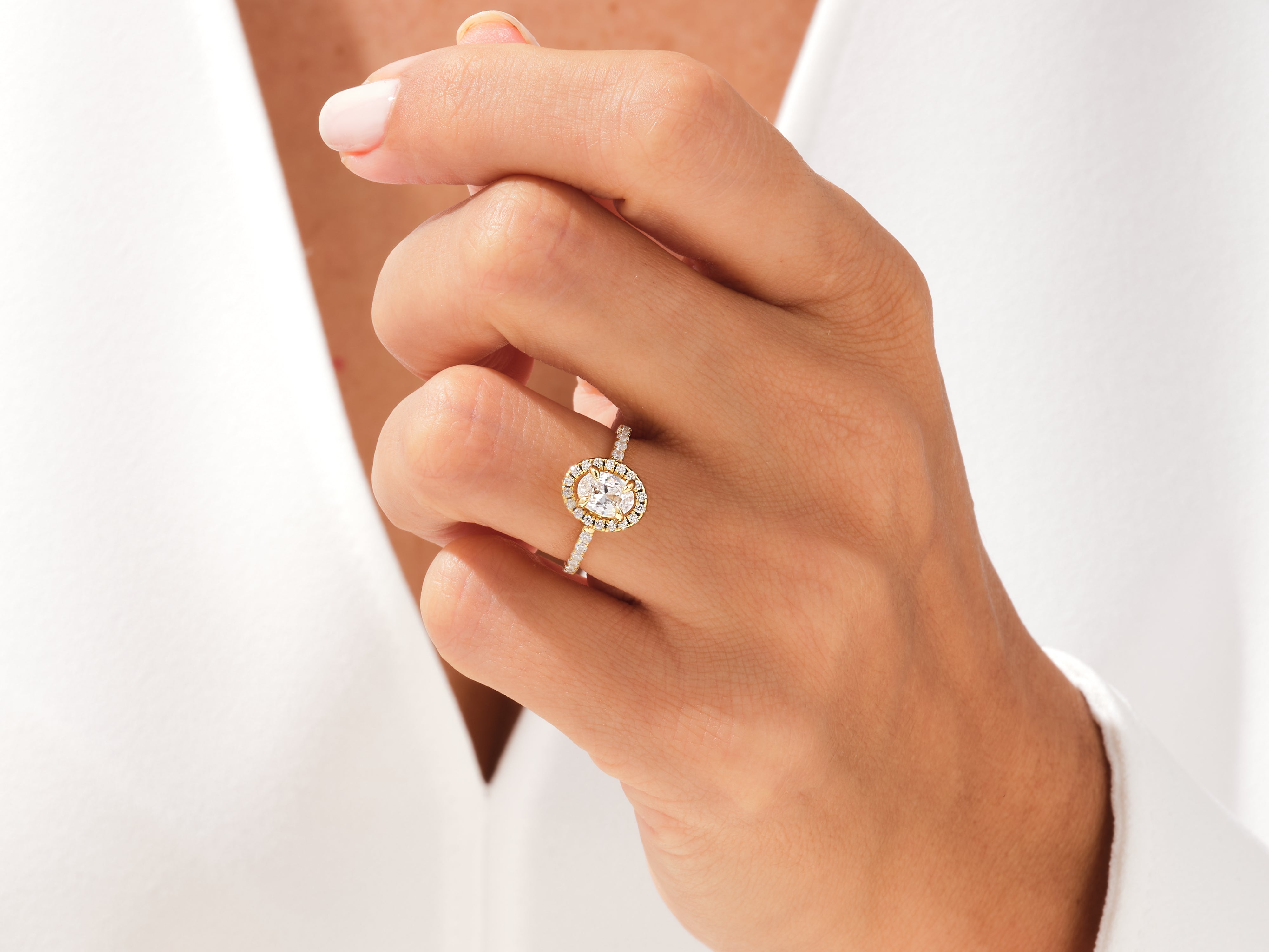 Diamond oval halo ring on hand, fine jewelry