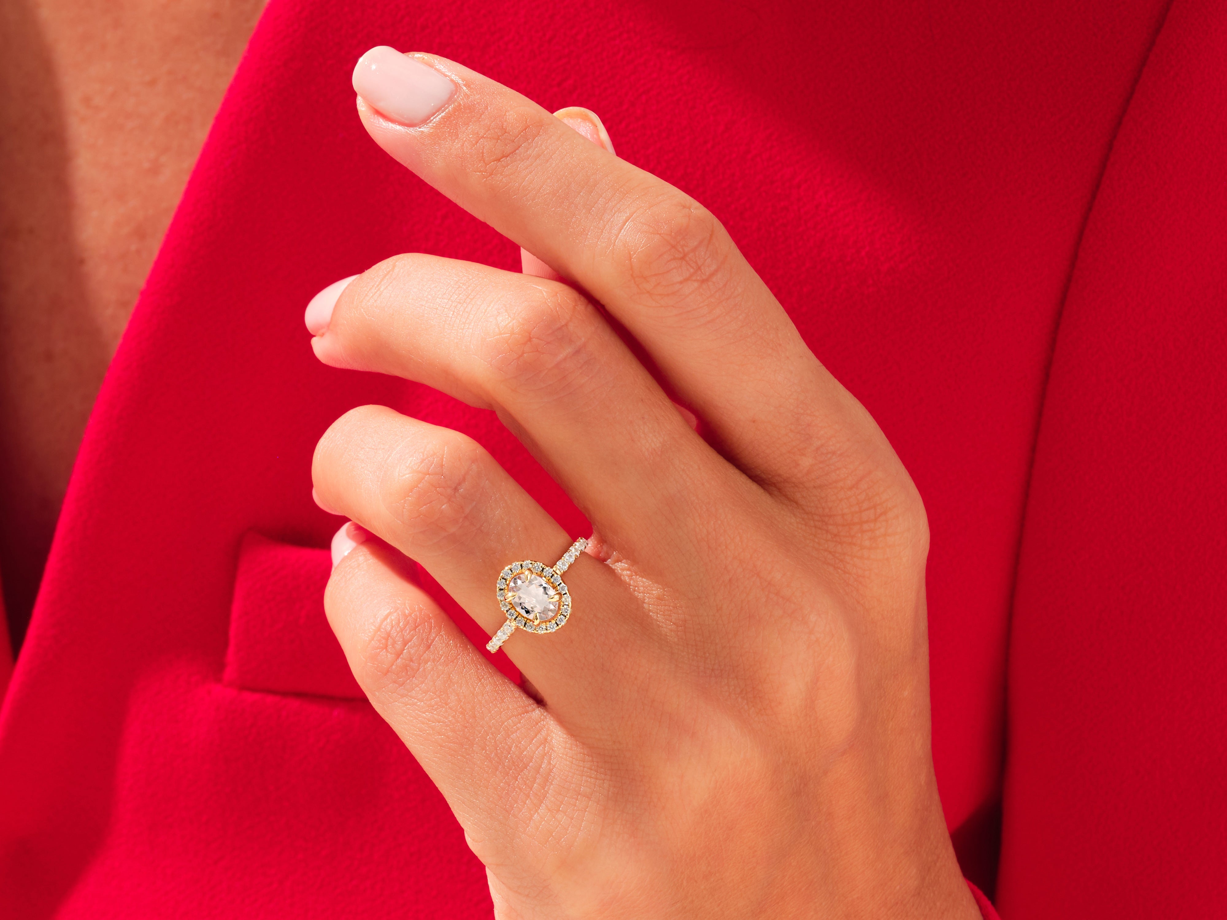 Diamond halo ring on hand, luxury jewelry