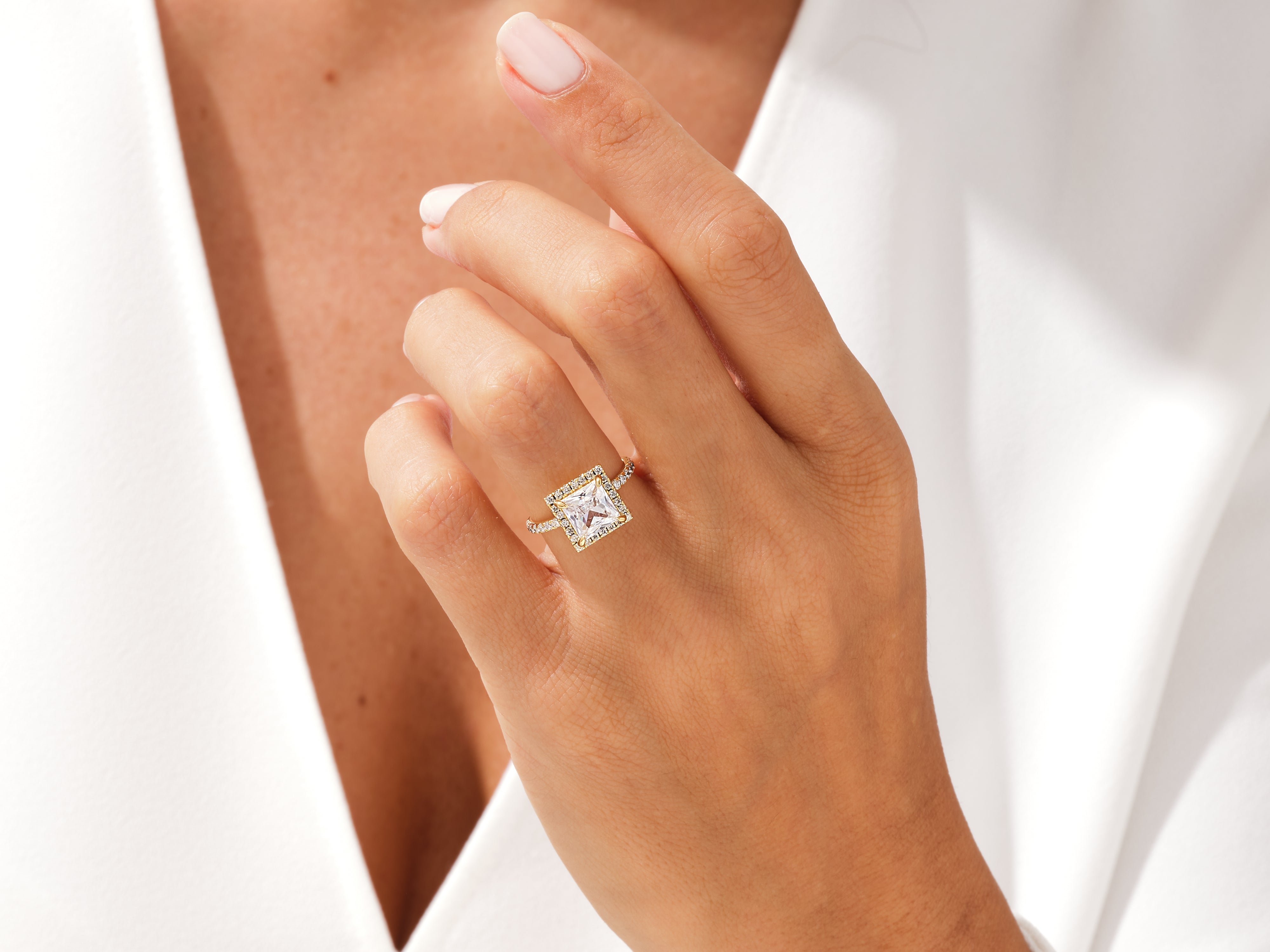 Princess cut diamond engagement ring with halo on hand