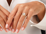 Pear-shaped diamond engagement ring with halo on a woman's hand