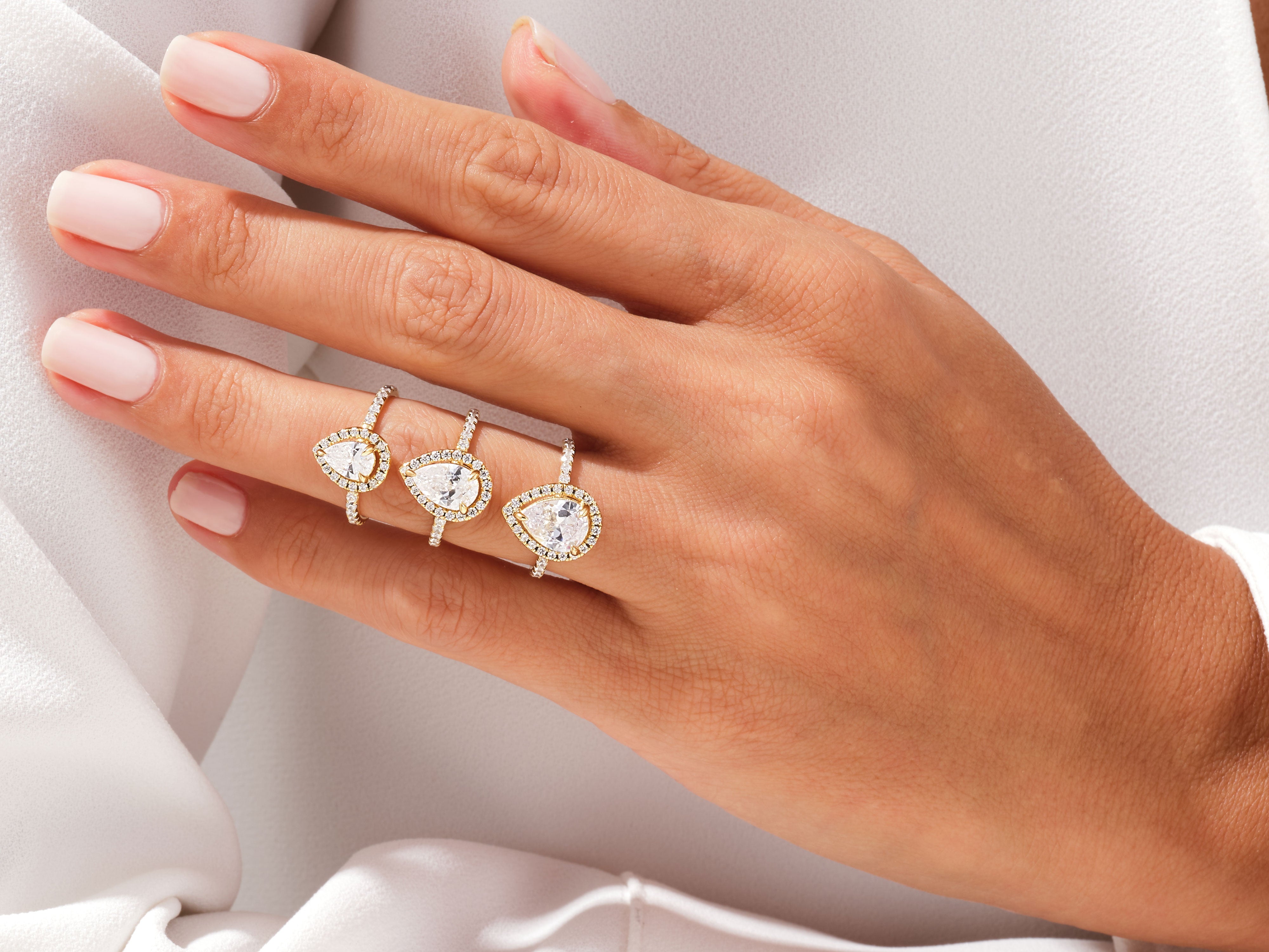 Diamond pear cut rings on a hand, jewelry collection