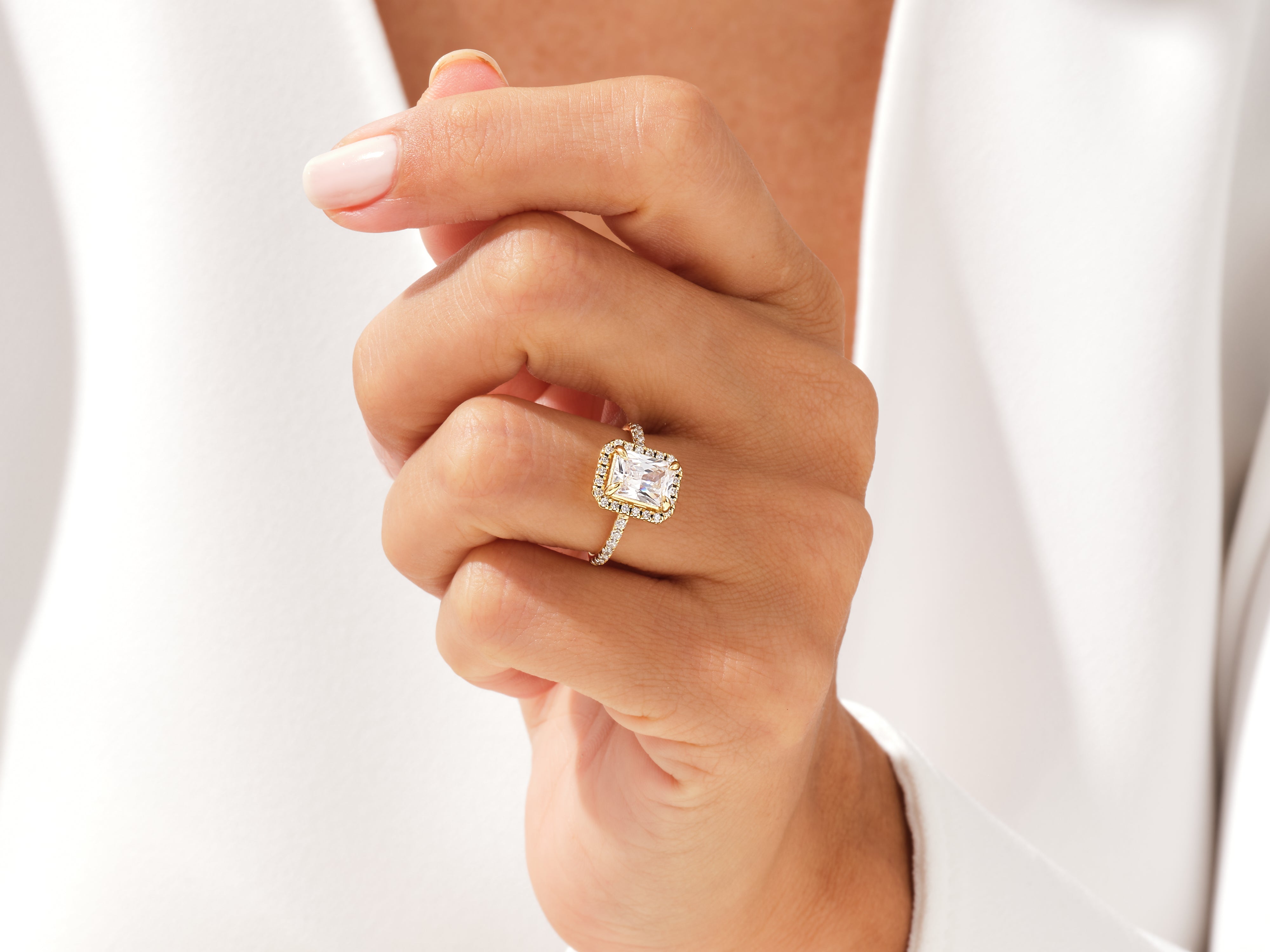 Emerald cut diamond engagement ring with pave band