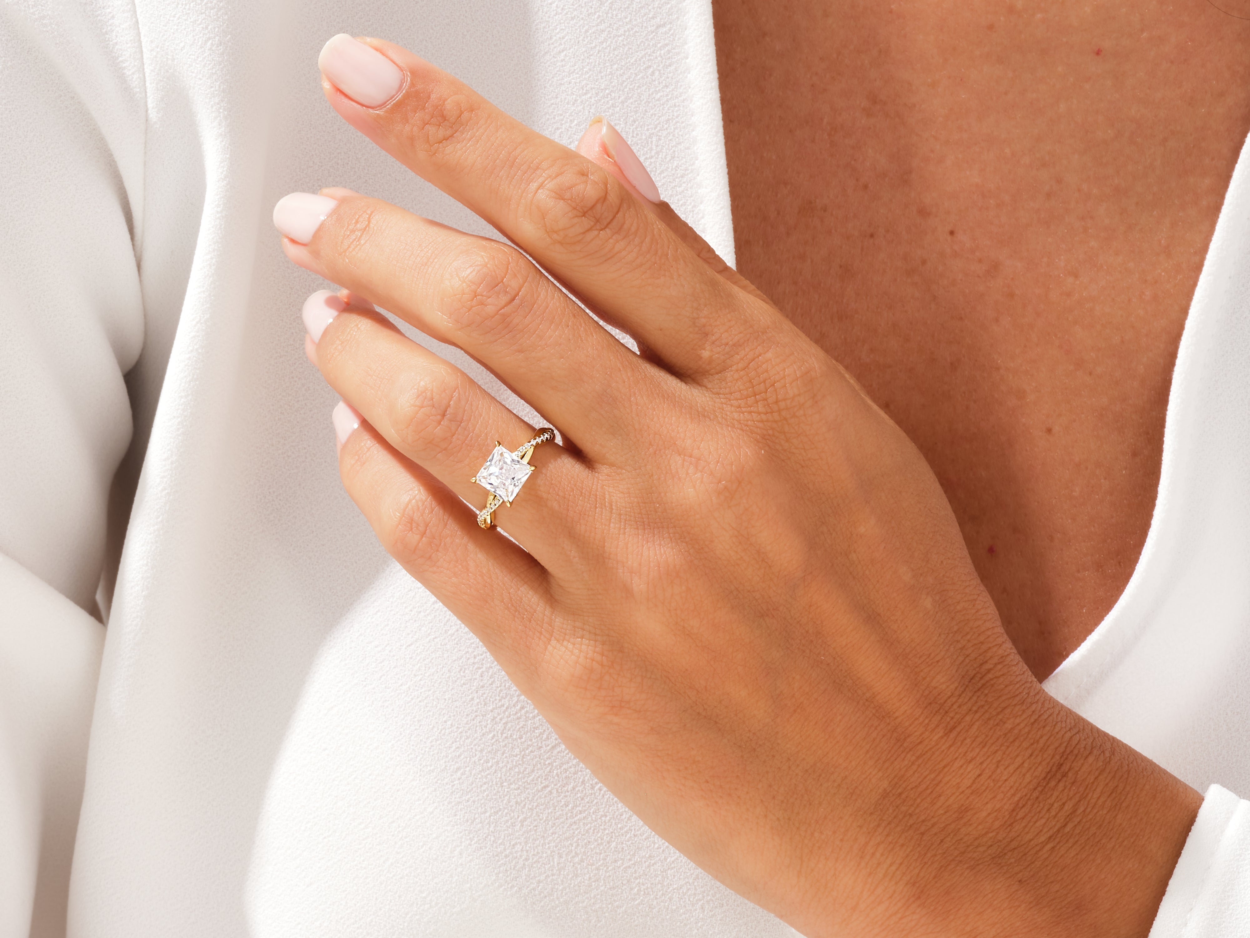 Gold princess cut diamond engagement ring on a woman's hand