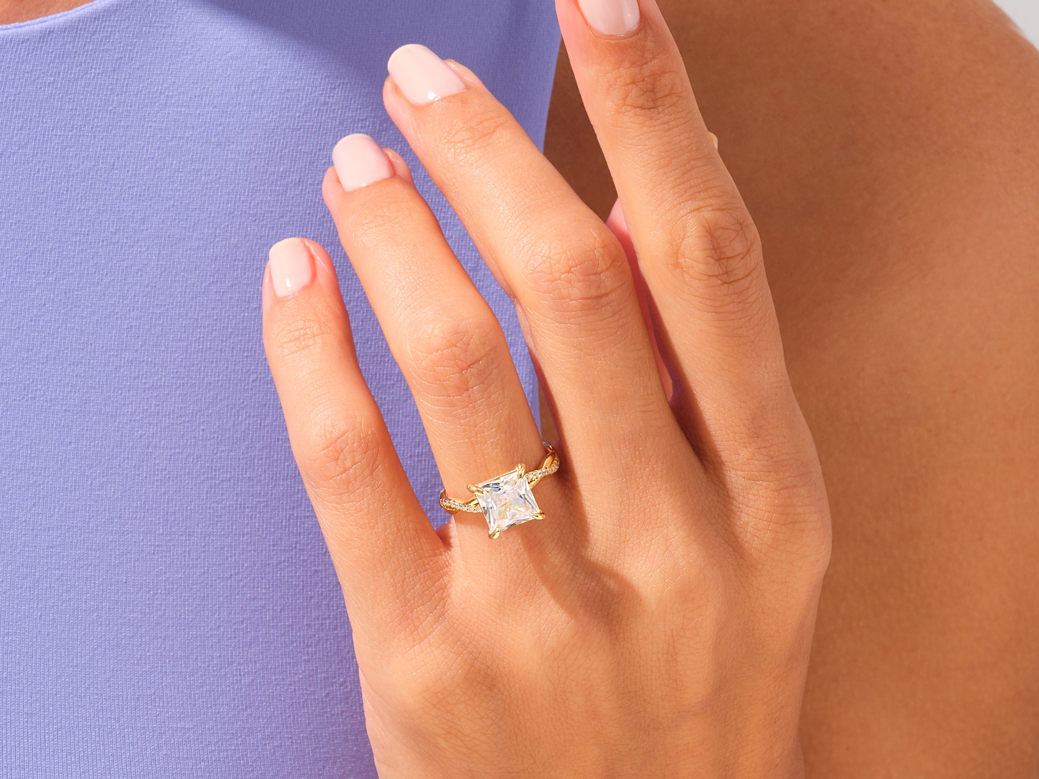 Gold princess cut diamond engagement ring on a woman's hand