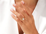 Gold pear-shaped diamond engagement ring on a woman's hand