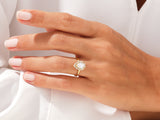 Pear-shaped diamond halo engagement ring on a hand
