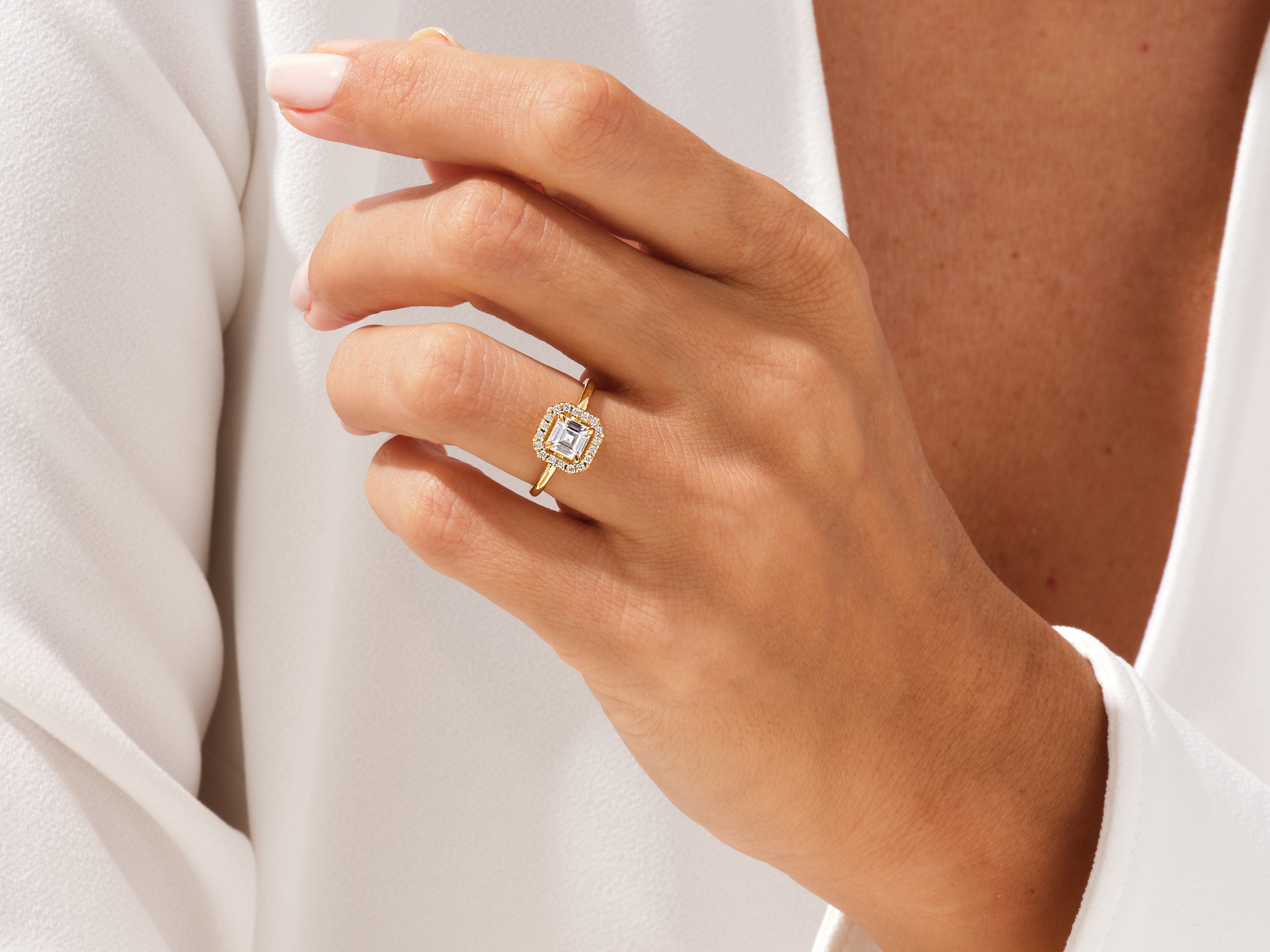 Gold ring with emerald cut diamond and halo, jewelry