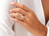 Gold diamond halo ring on a woman's hand