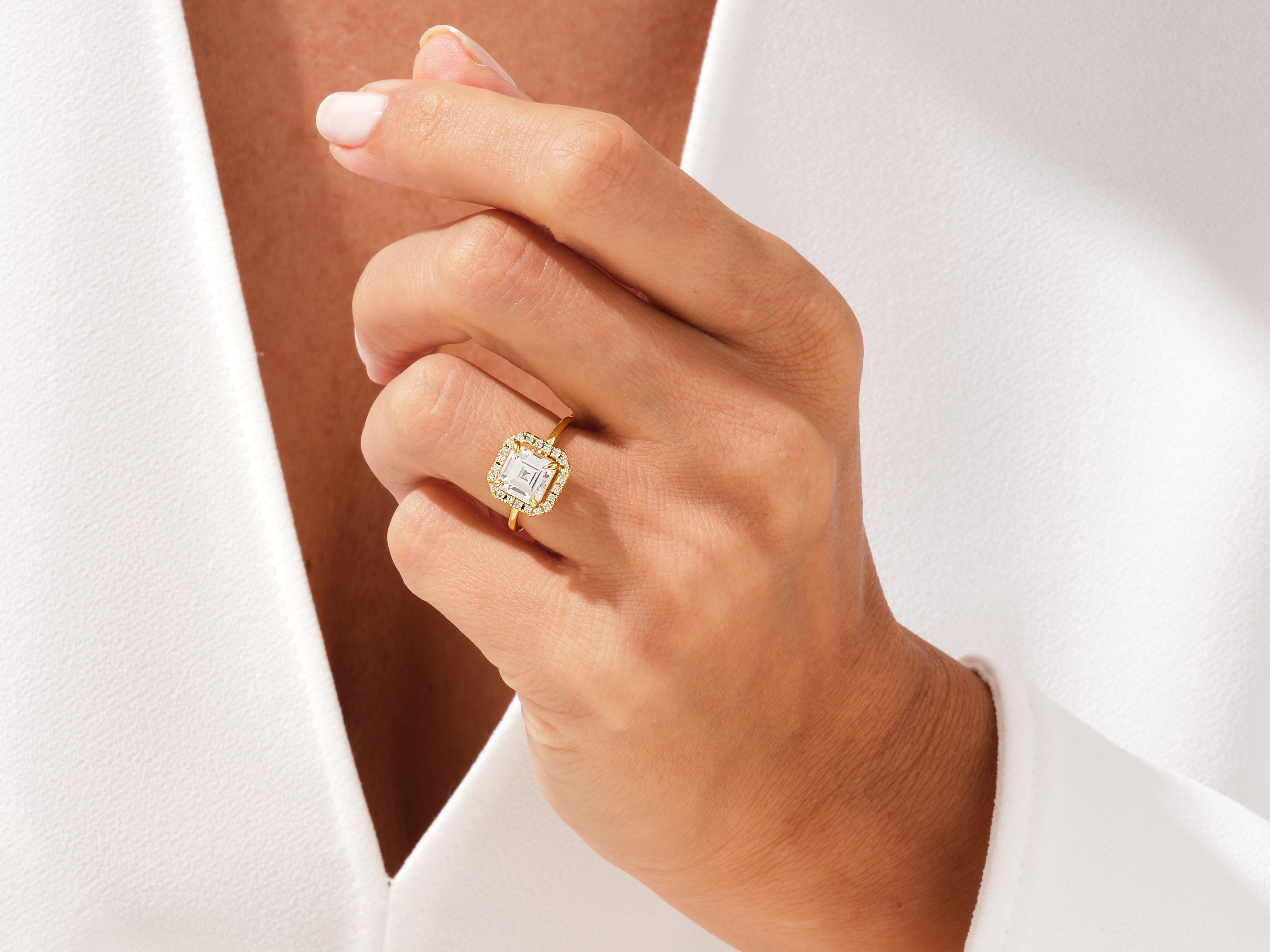 Gold diamond halo ring on hand, luxury jewelry