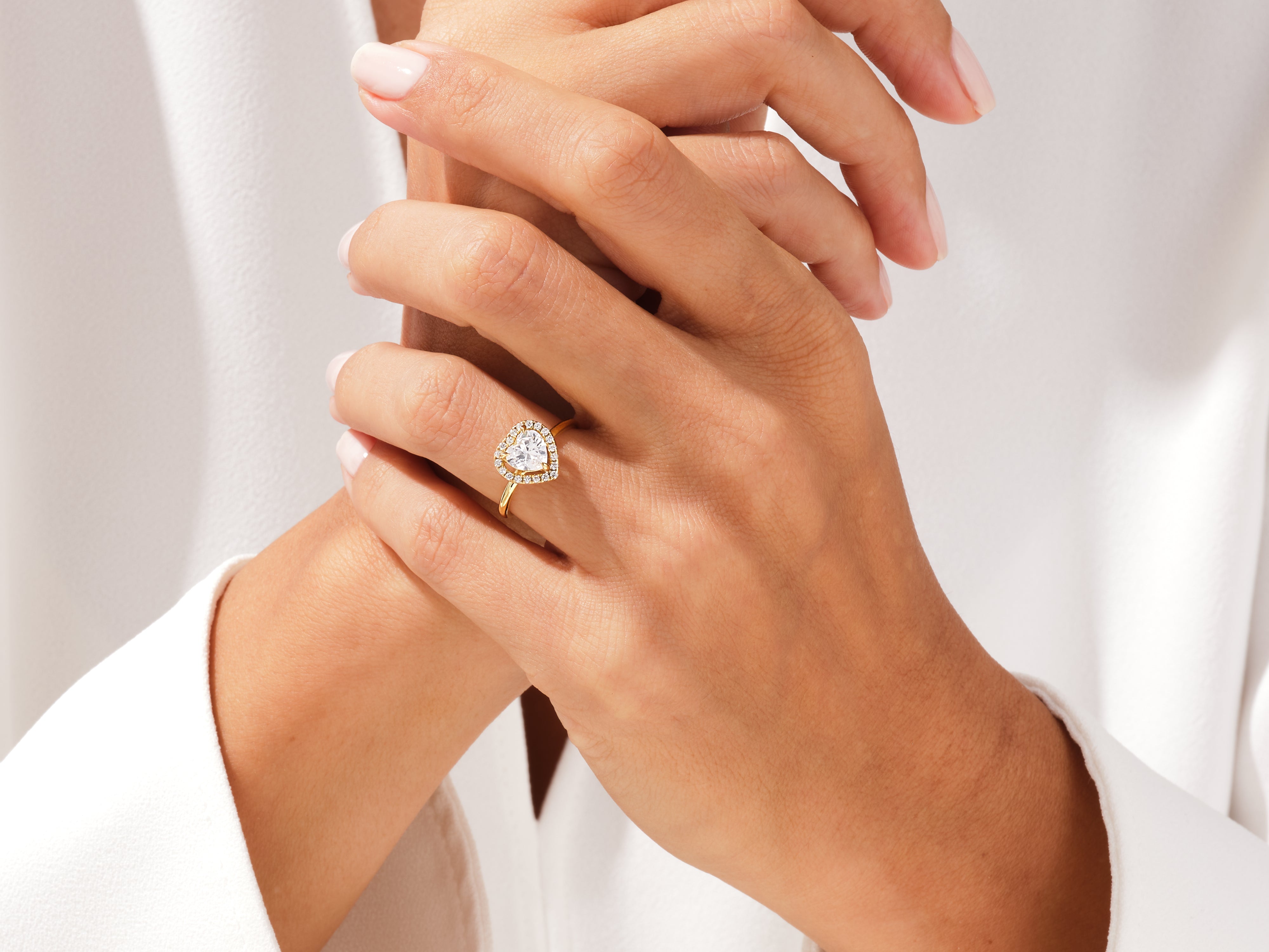 Heart-shaped diamond engagement ring on a woman's hand