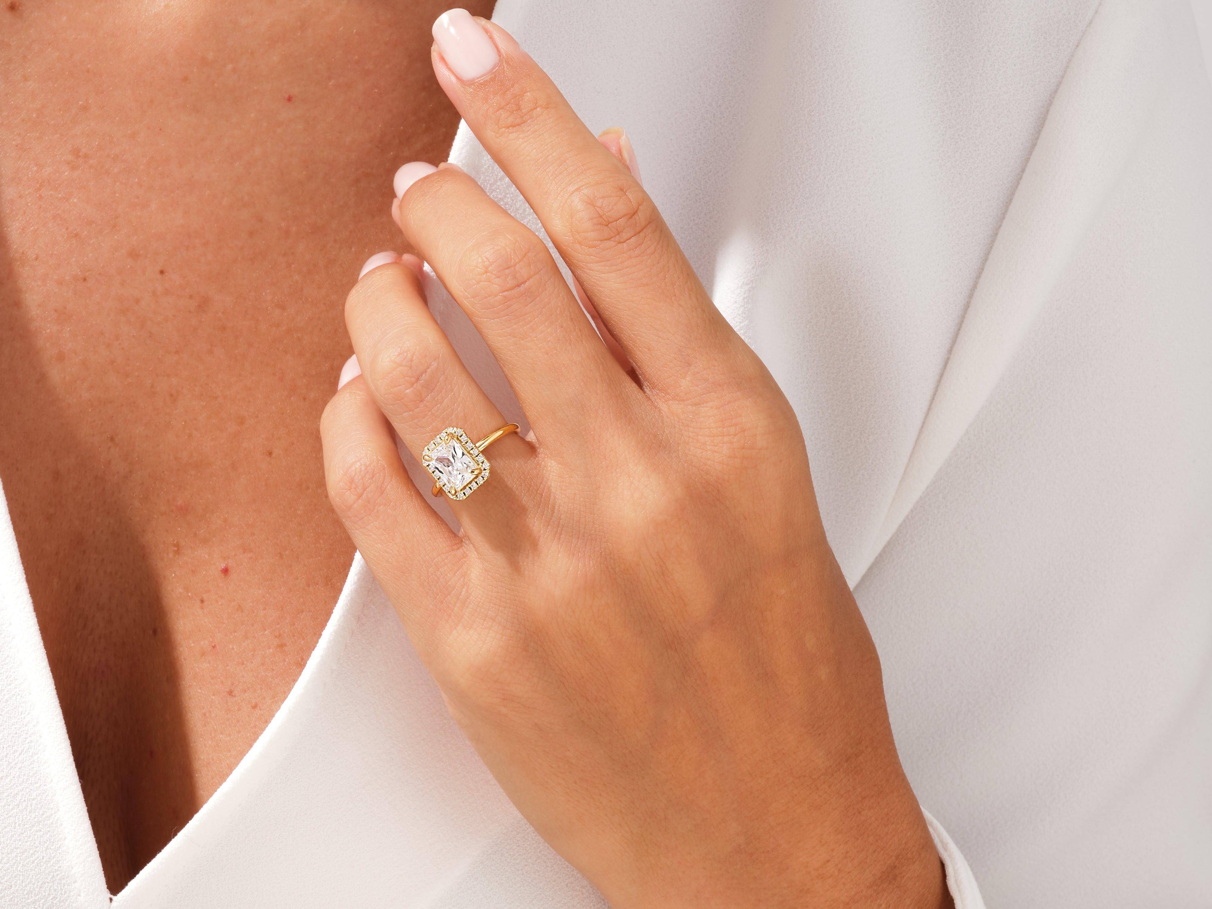 Gold engagement ring with radiant cut diamond and halo setting