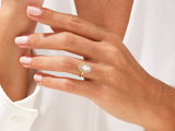 Gold marquise diamond halo ring on a woman's finger