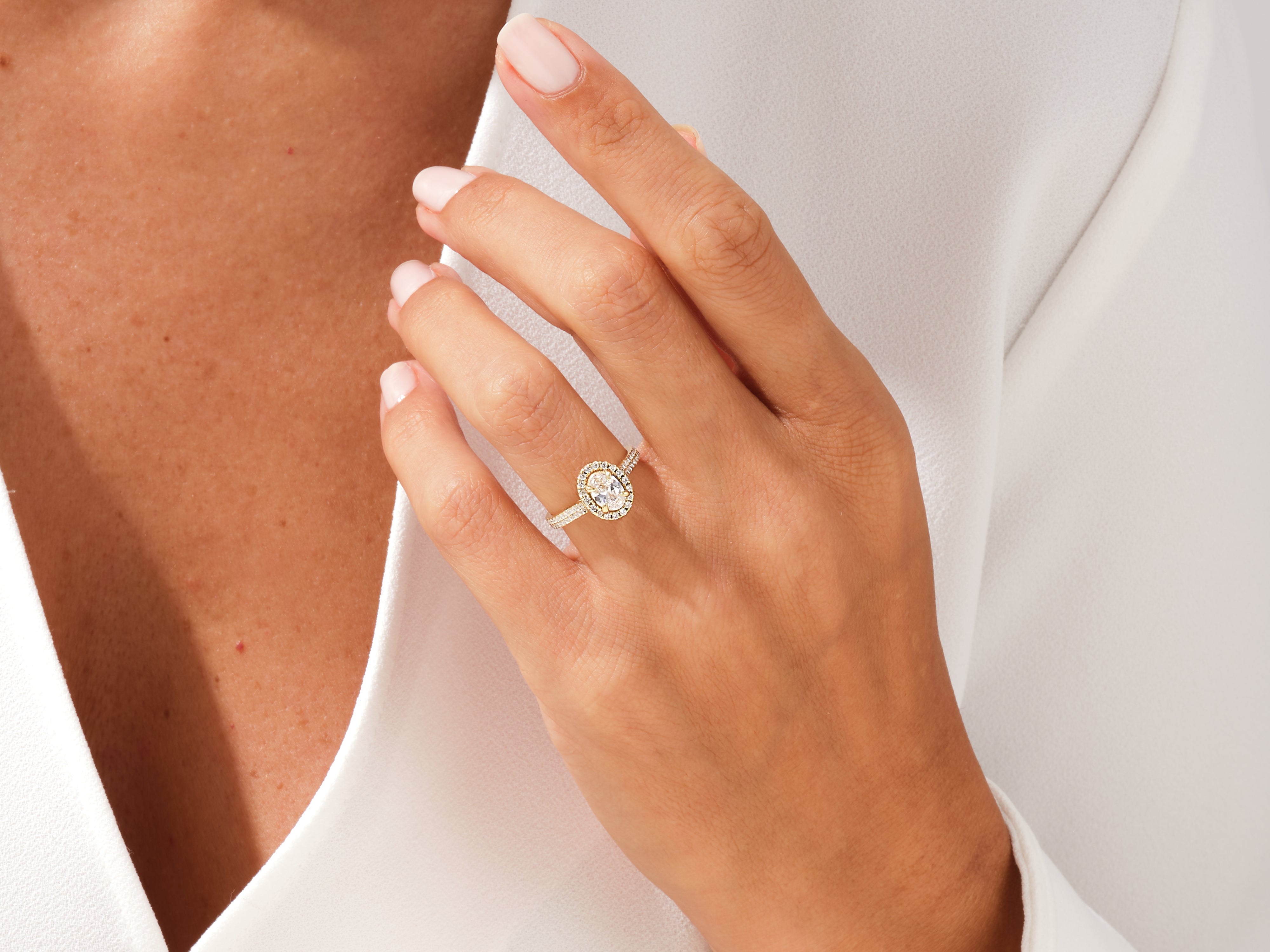 Diamond engagement ring with oval center stone and halo setting