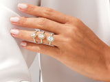 Three diamond halo engagement rings on a hand