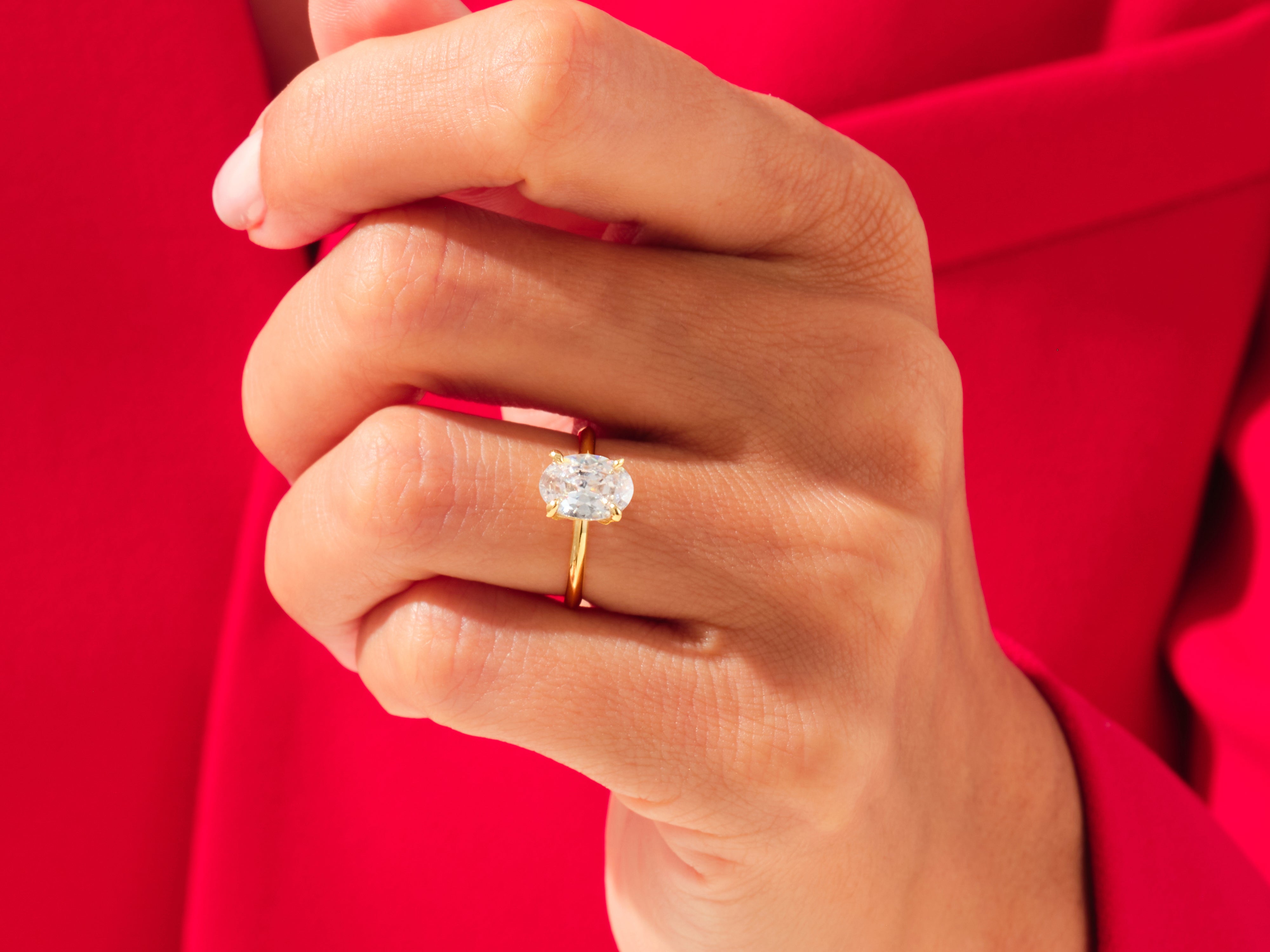 Oval diamond engagement ring on a hand, jewelry