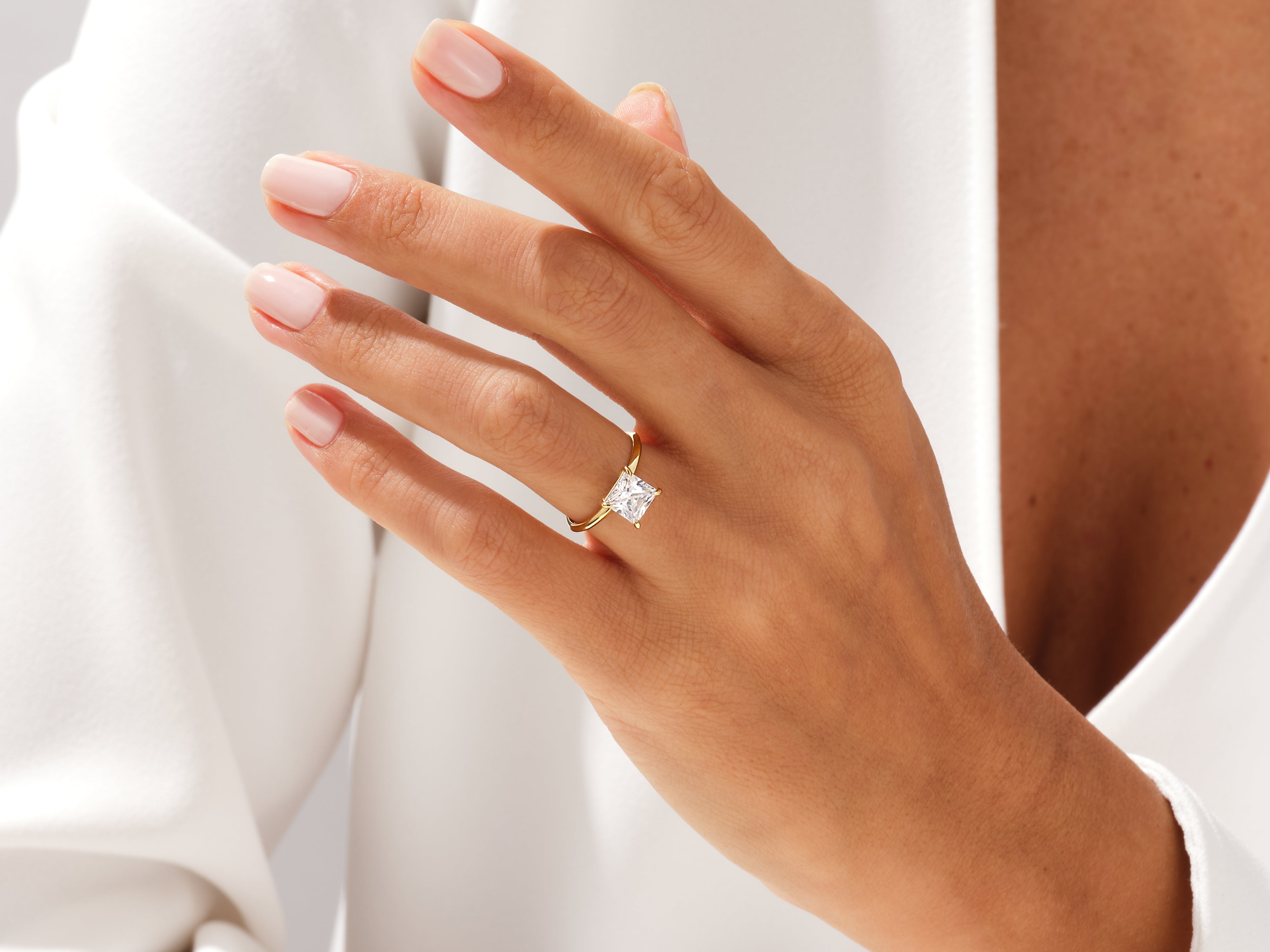 Gold princess cut diamond engagement ring on hand