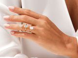 Three gold rings with emerald-cut diamonds on a hand