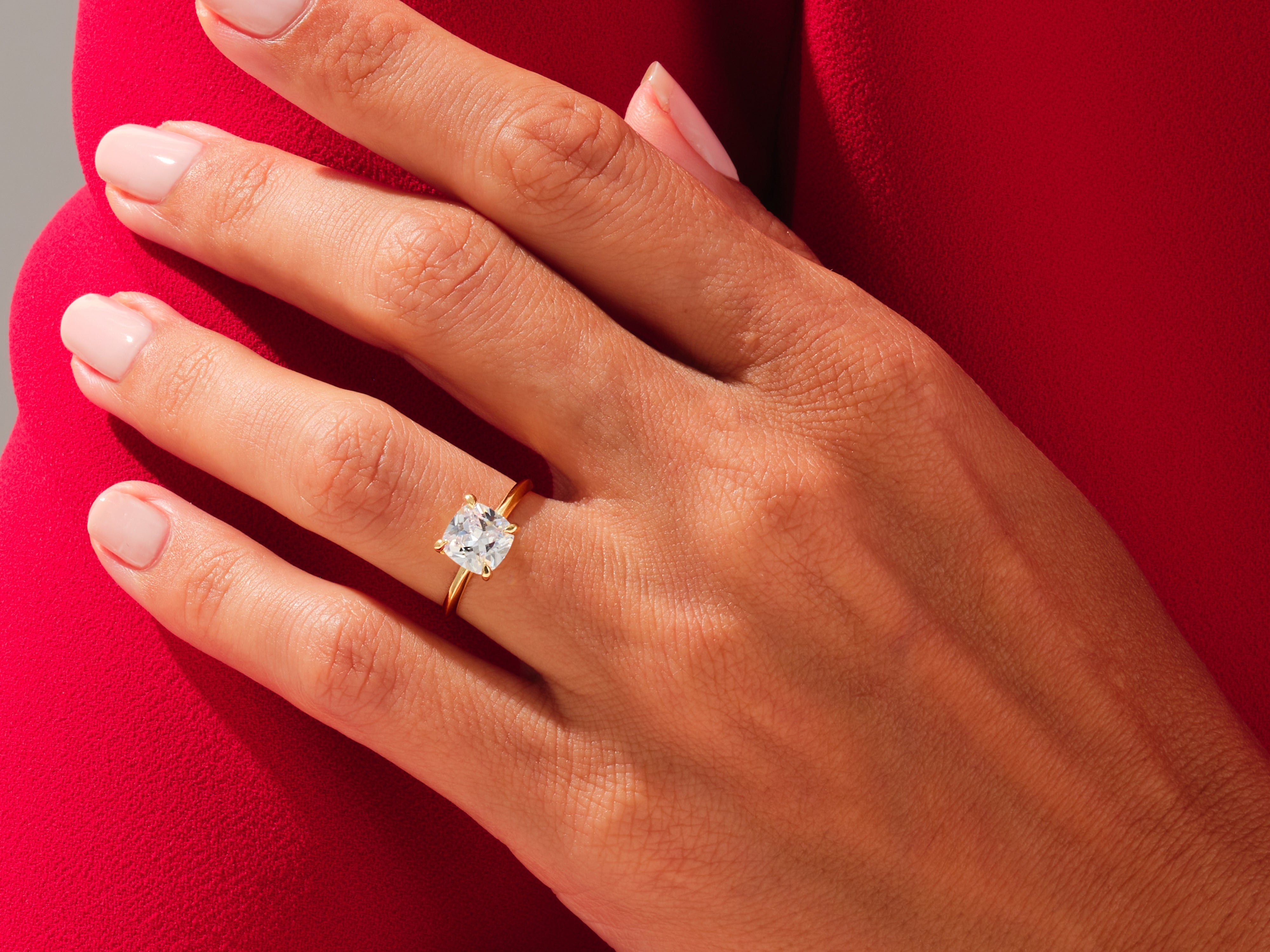 Gold ring with cushion-cut diamond on hand