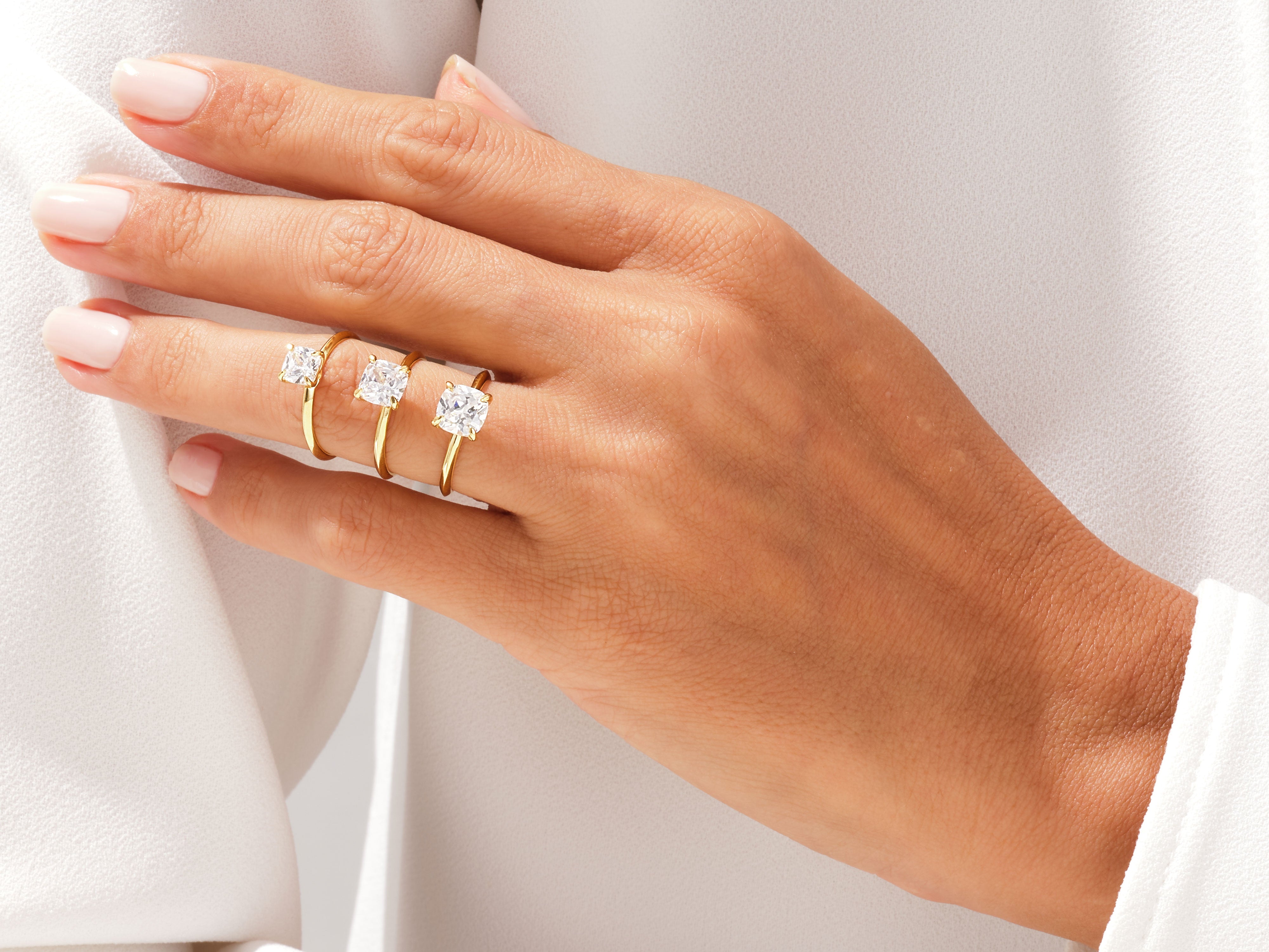 Diamond engagement rings on a hand, jewelry collection