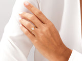 Gold pear-shaped diamond engagement ring on a woman's hand