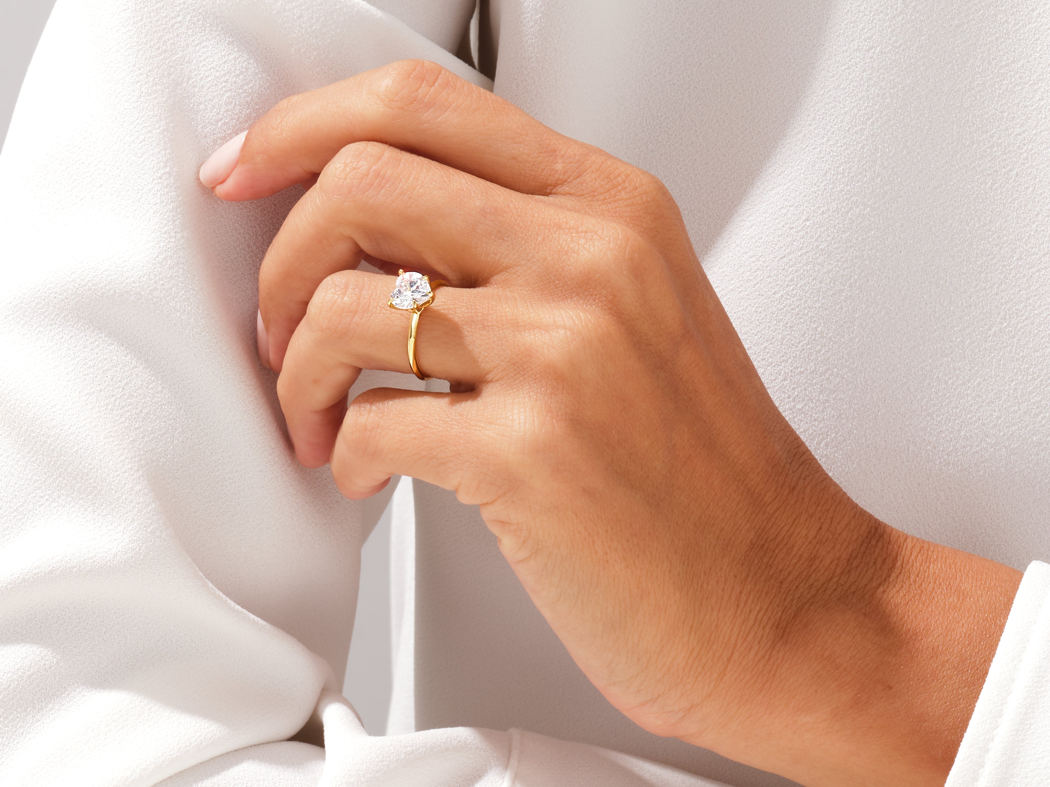 Gold ring with heart-shaped diamond on a woman's hand