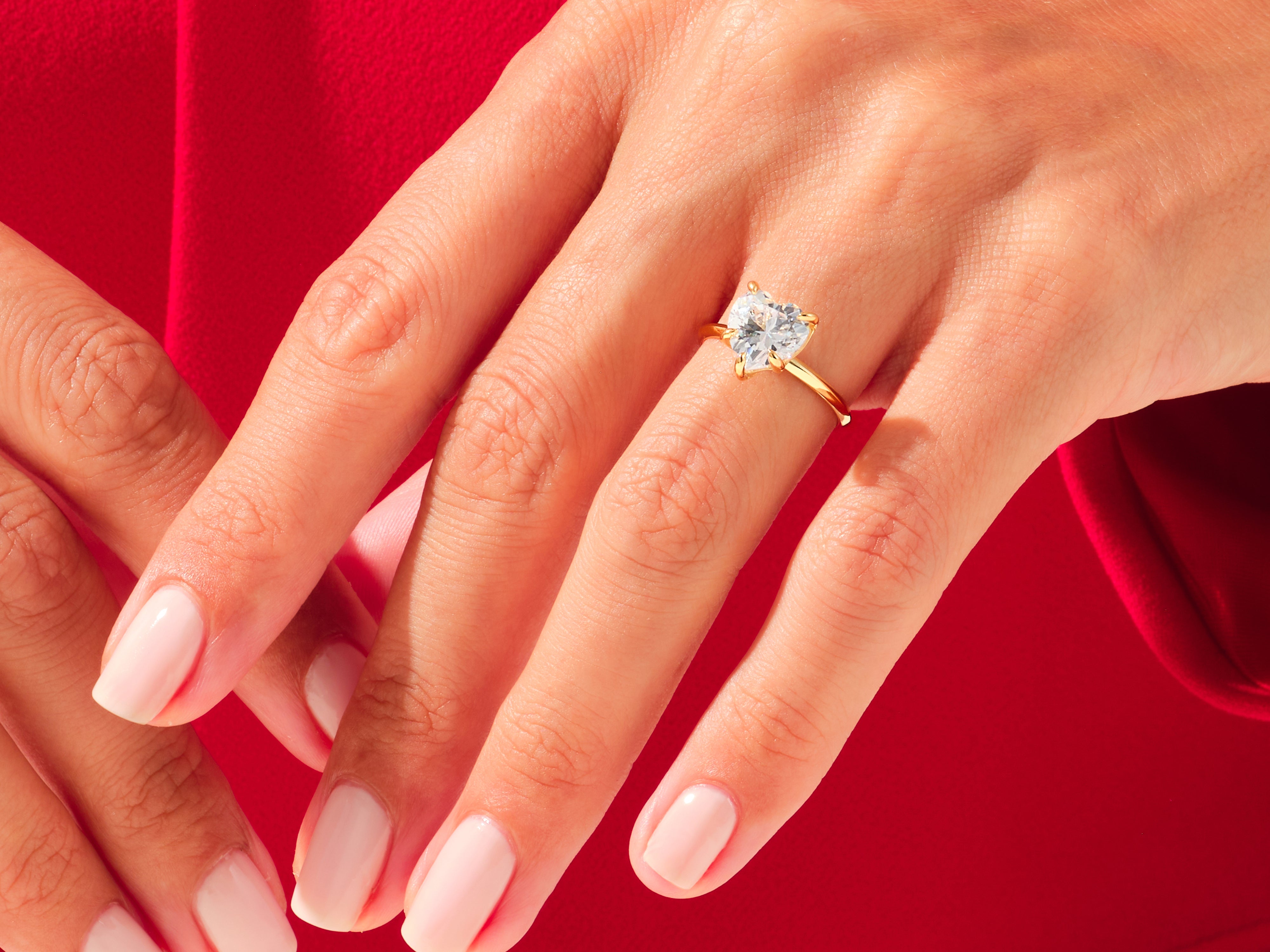 Heart-shaped diamond ring on a woman's hand, jewelry
