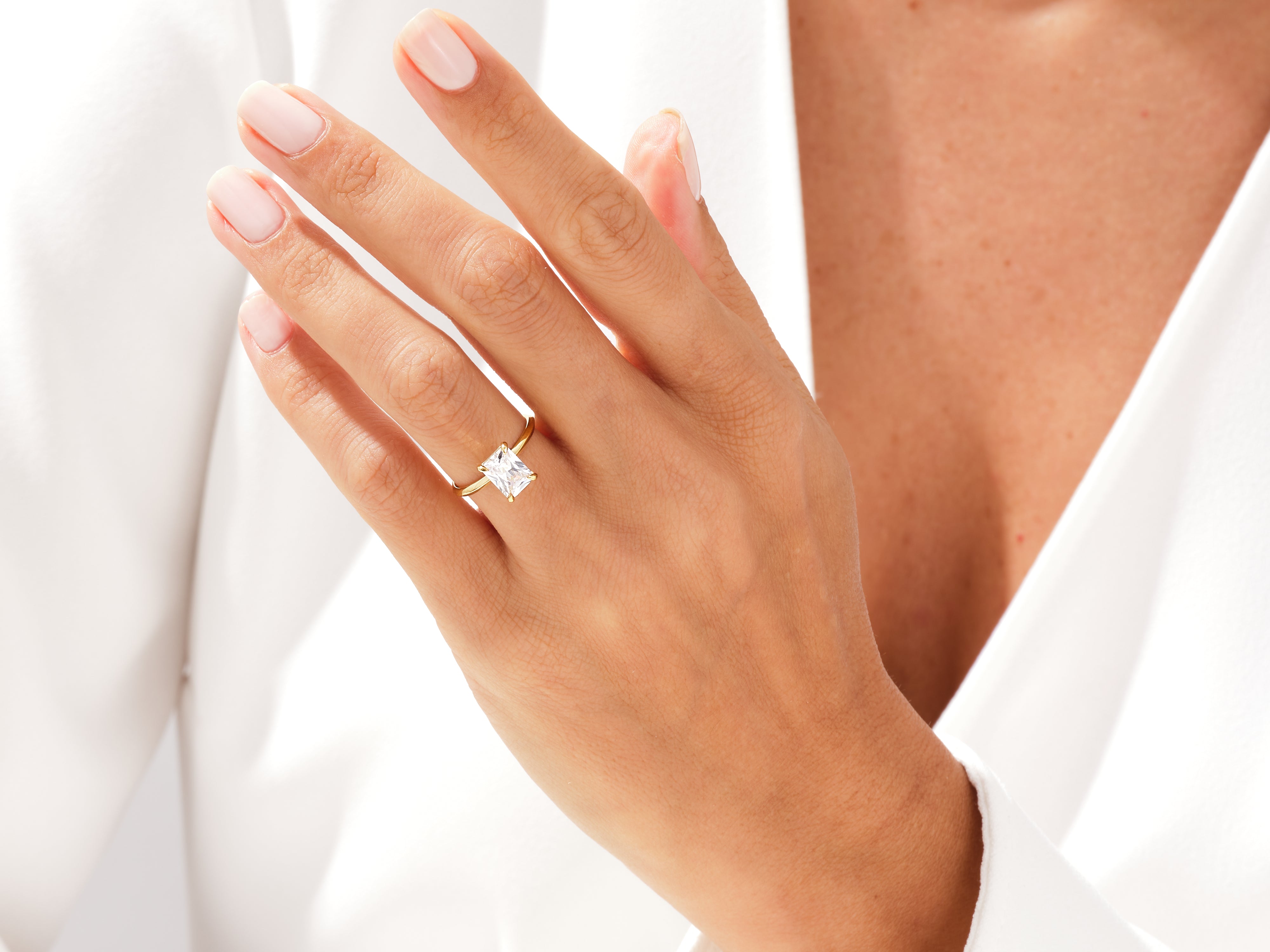 Gold ring with radiant cut diamond on a woman's hand