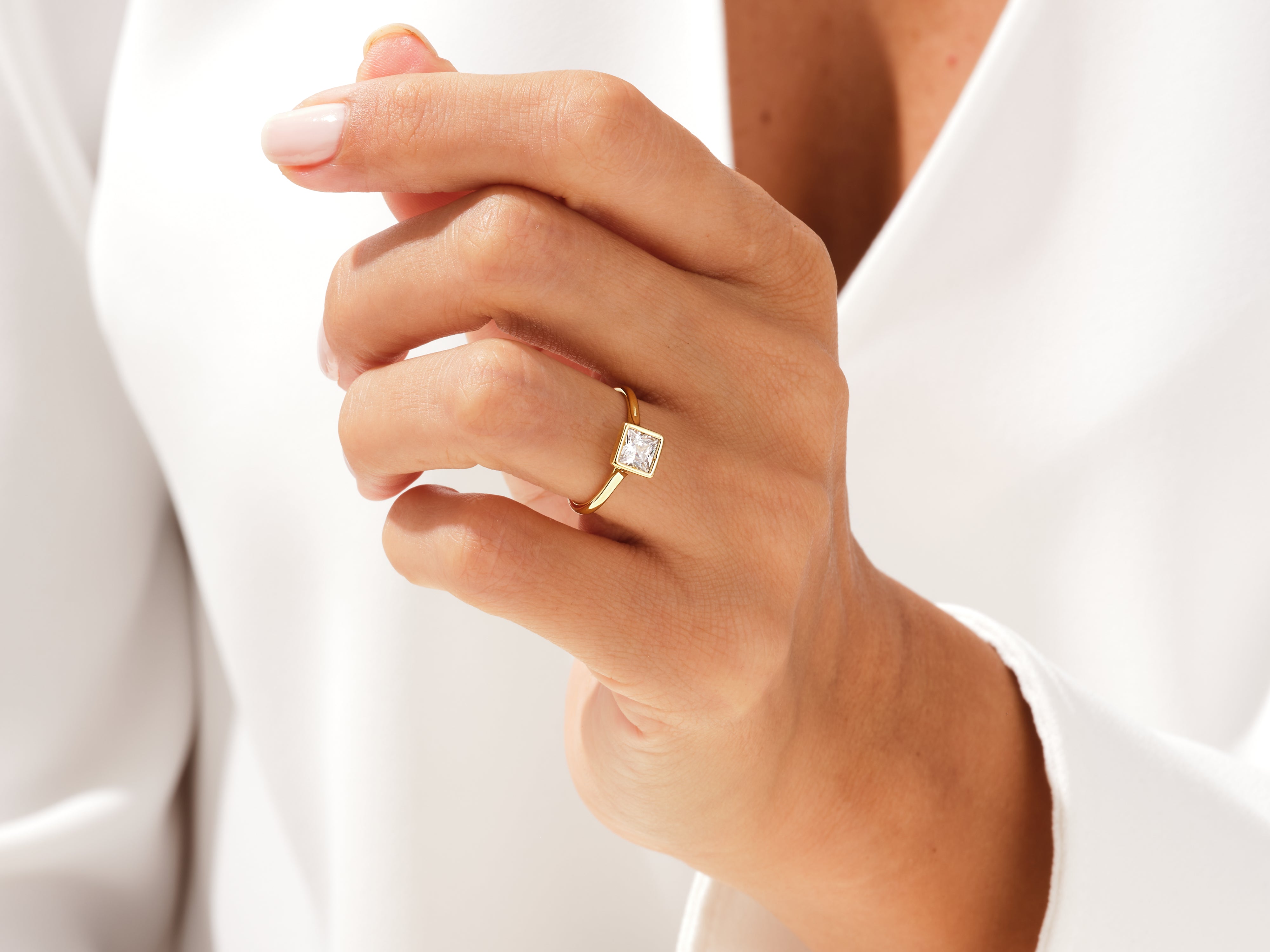Gold ring with princess cut diamond on hand
