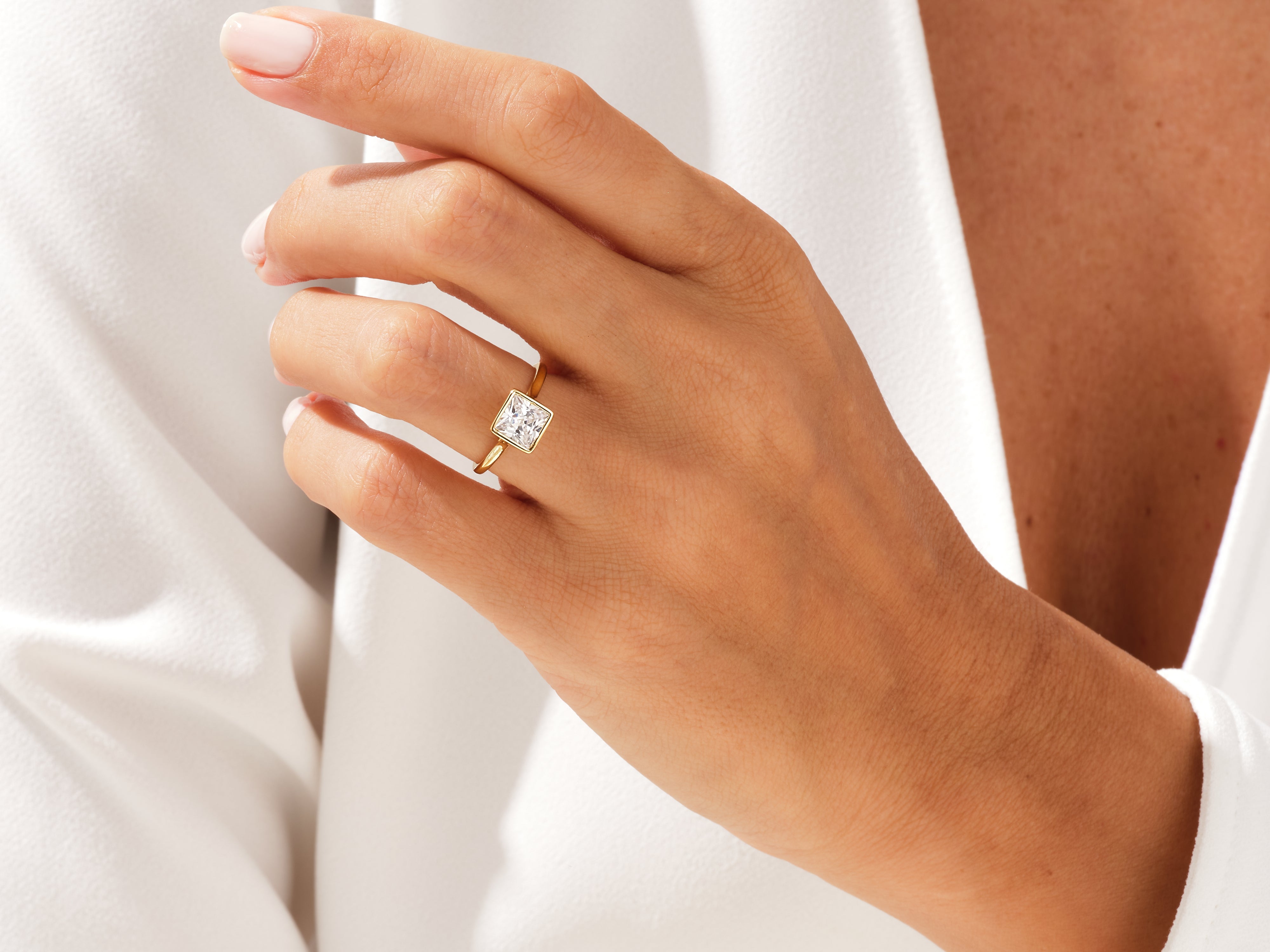Gold ring with princess cut diamond on hand