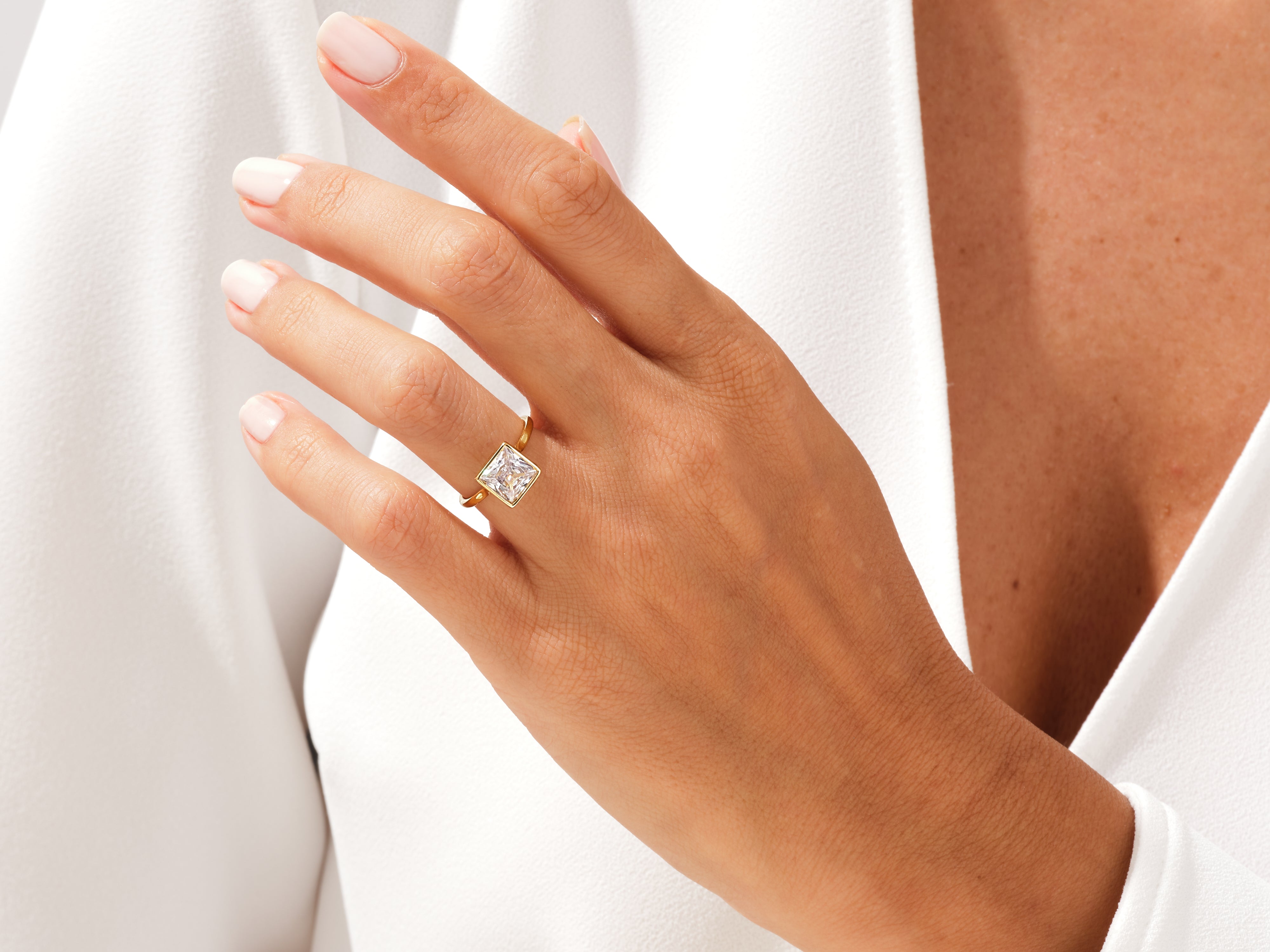 Gold ring with princess cut diamond on a woman's hand
