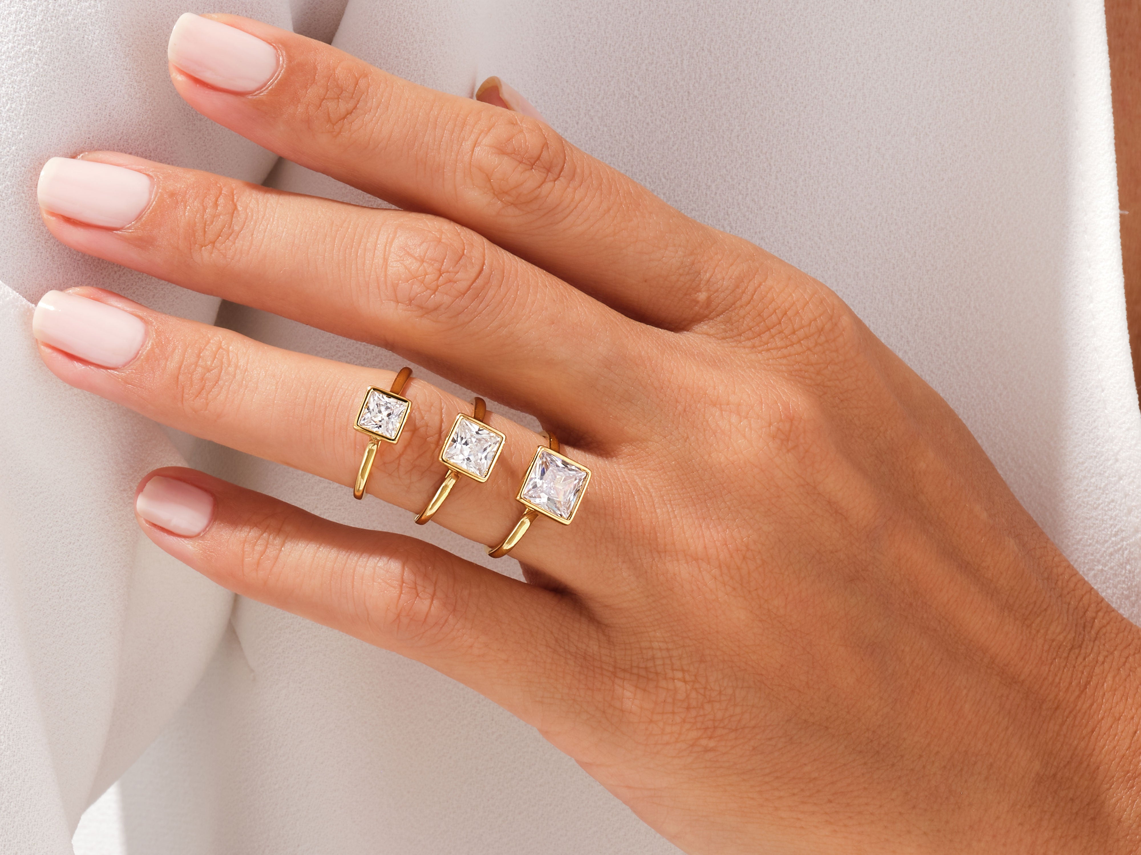 Gold rings with square diamonds on a woman's hand
