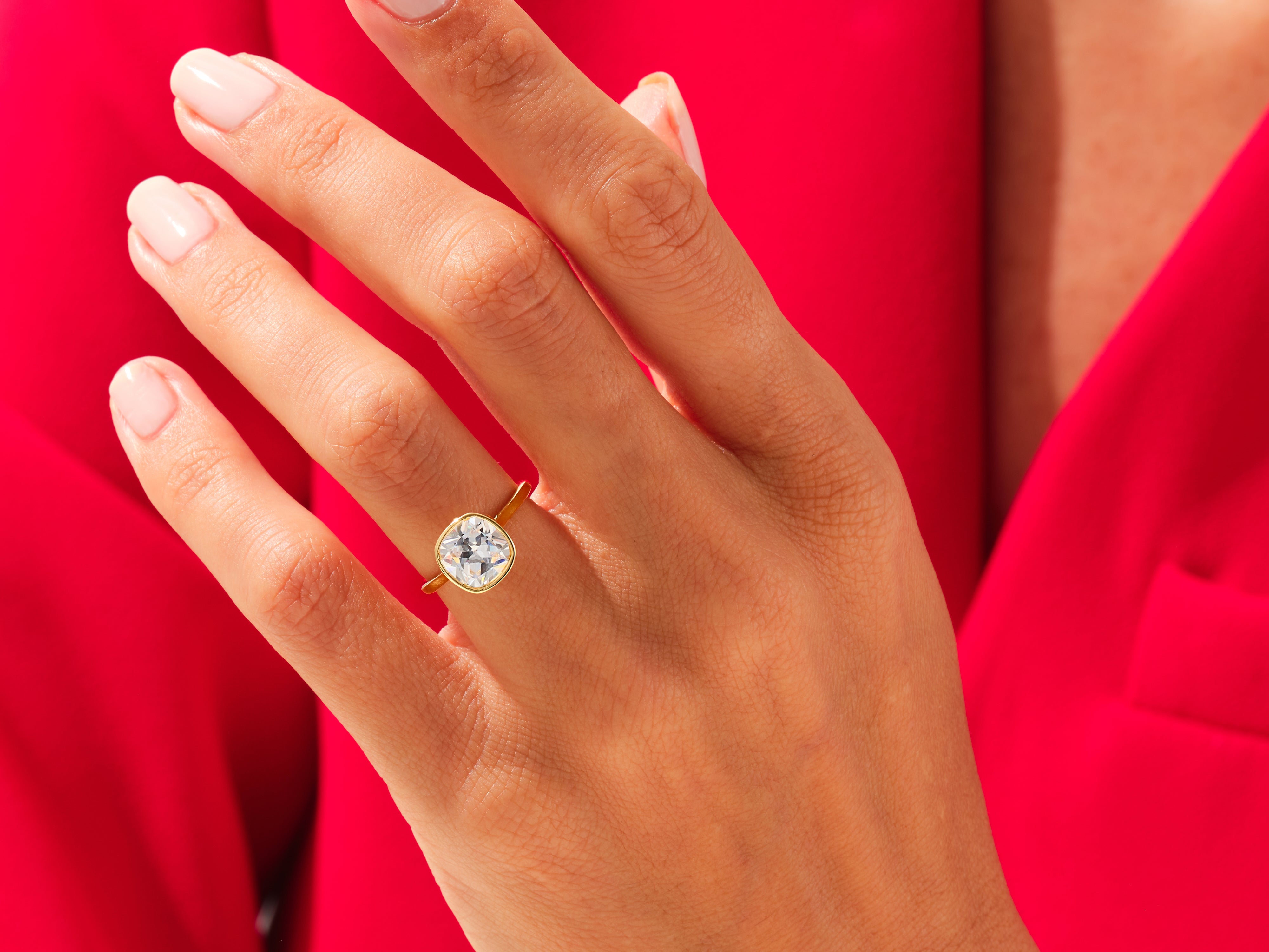 Gold ring with cushion cut diamond on hand