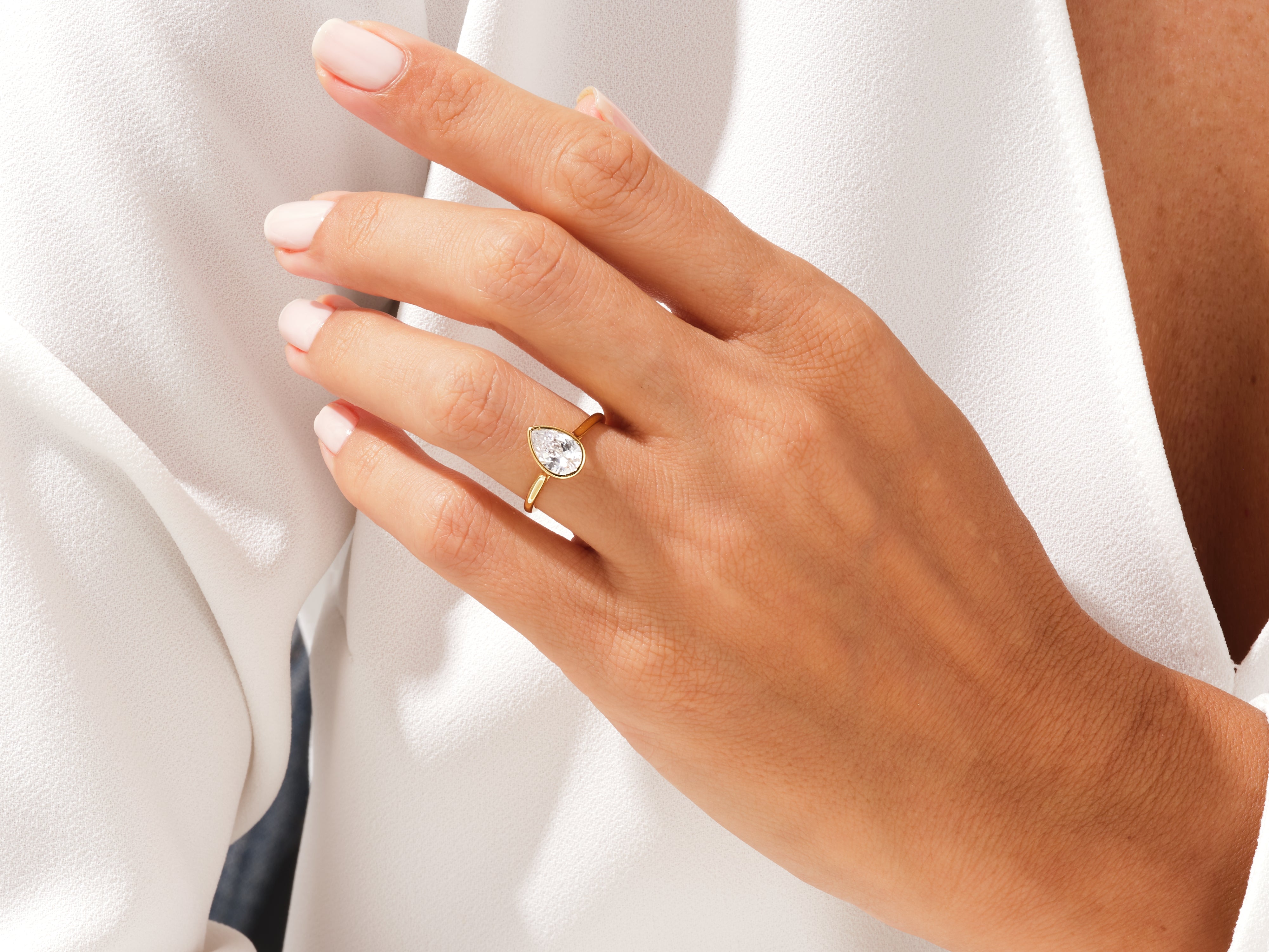 Pear-shaped diamond engagement ring on a woman's hand