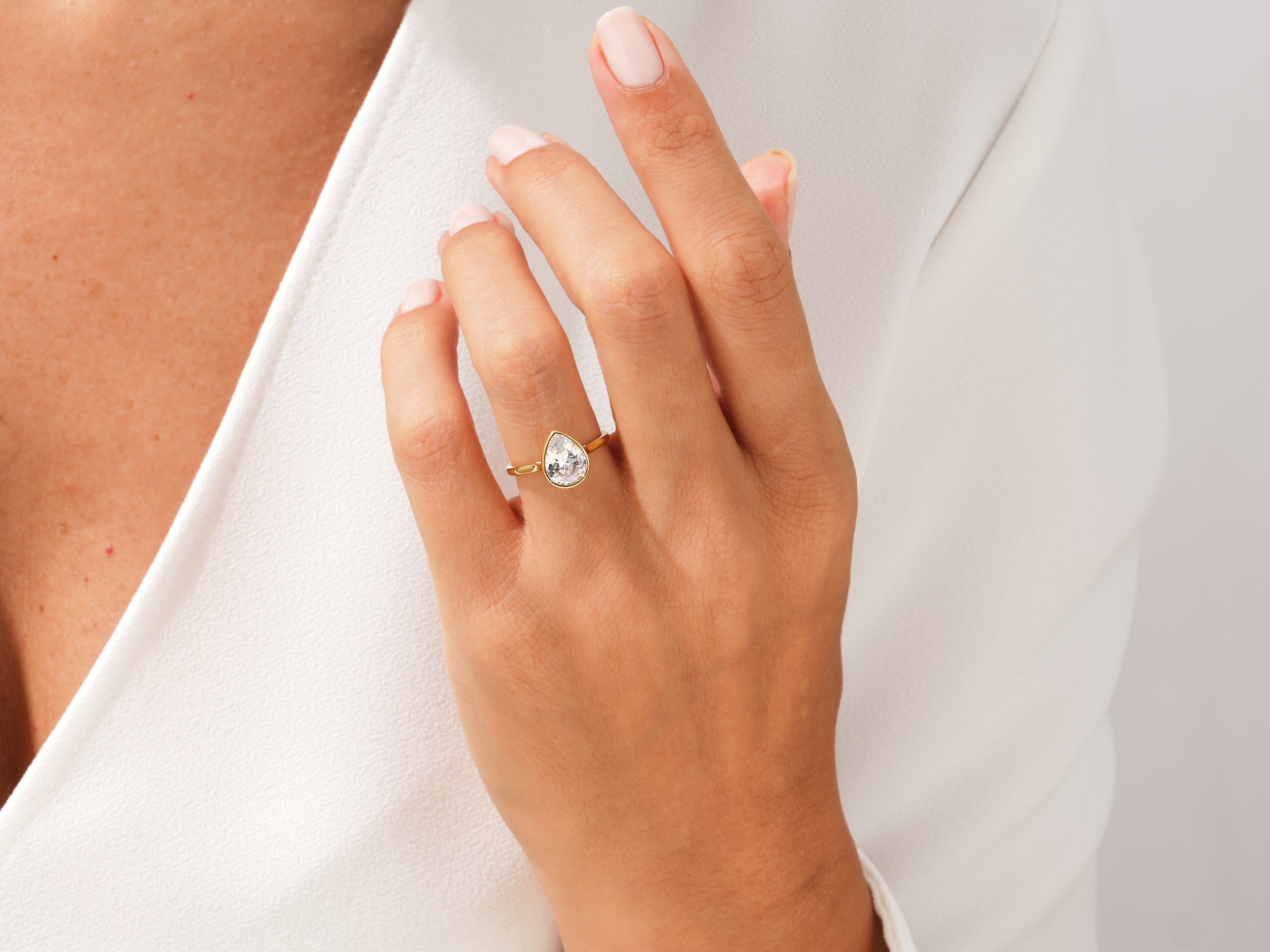 Gold pear-shaped diamond ring on a woman's hand