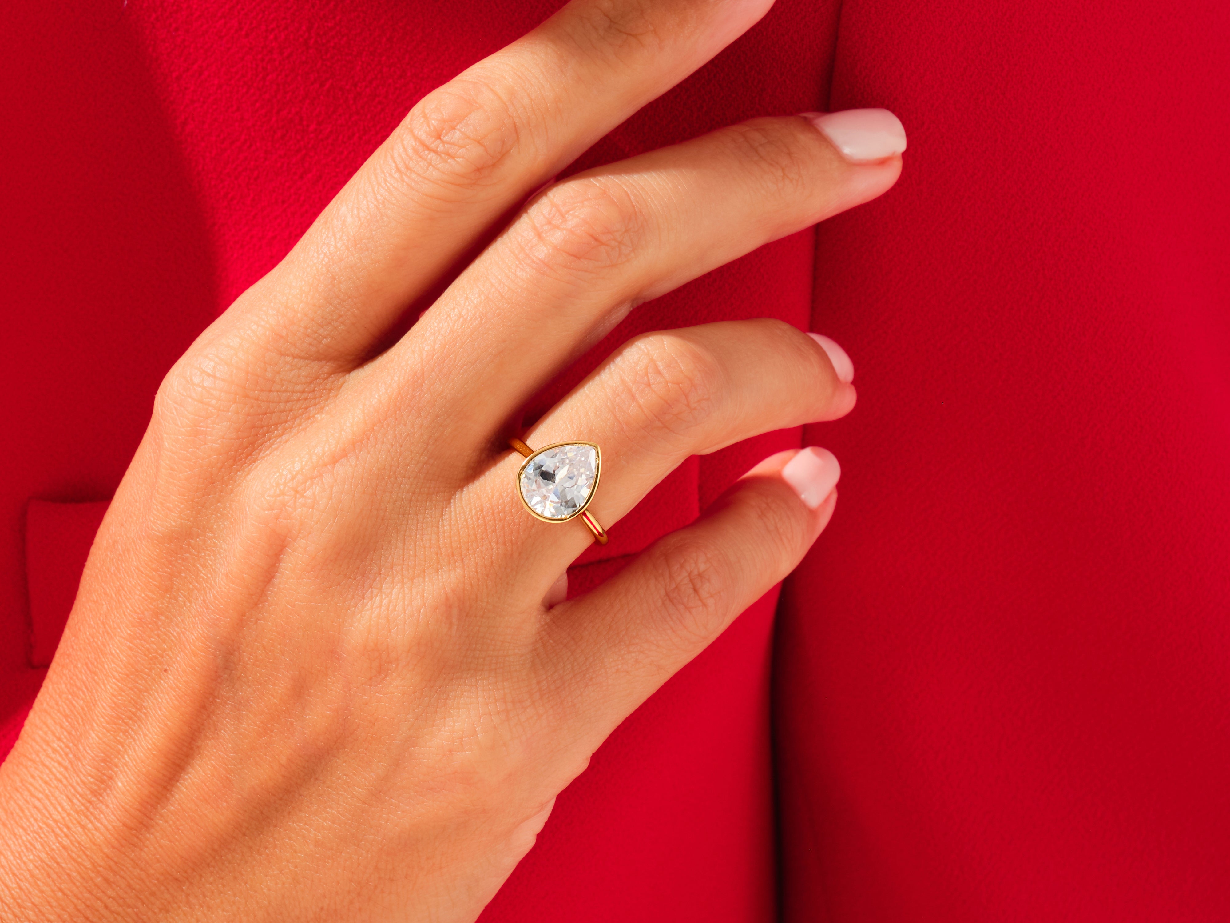 Pear-shaped diamond ring on hand, luxury jewelry
