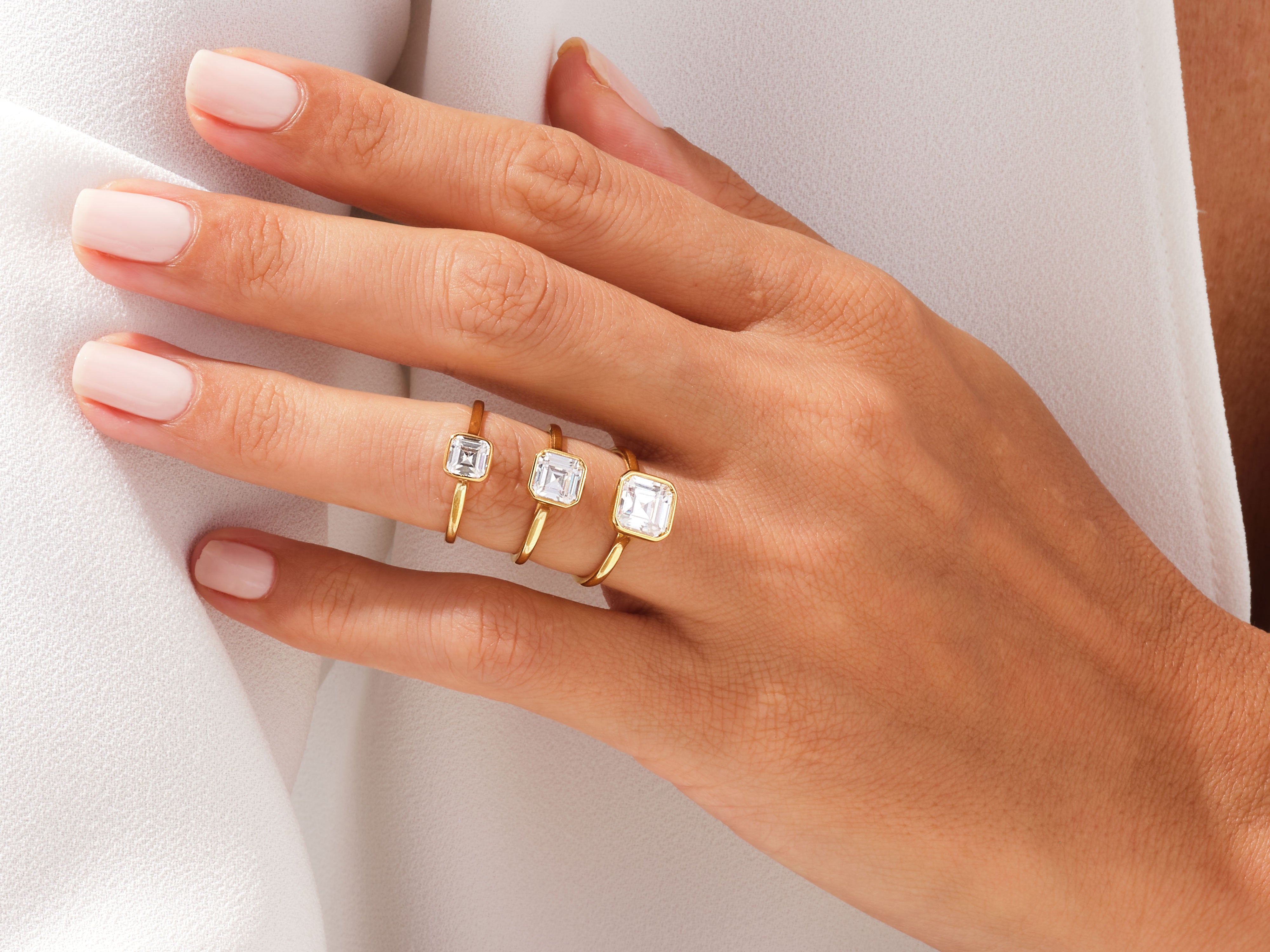 Gold rings with square cut diamonds on a hand