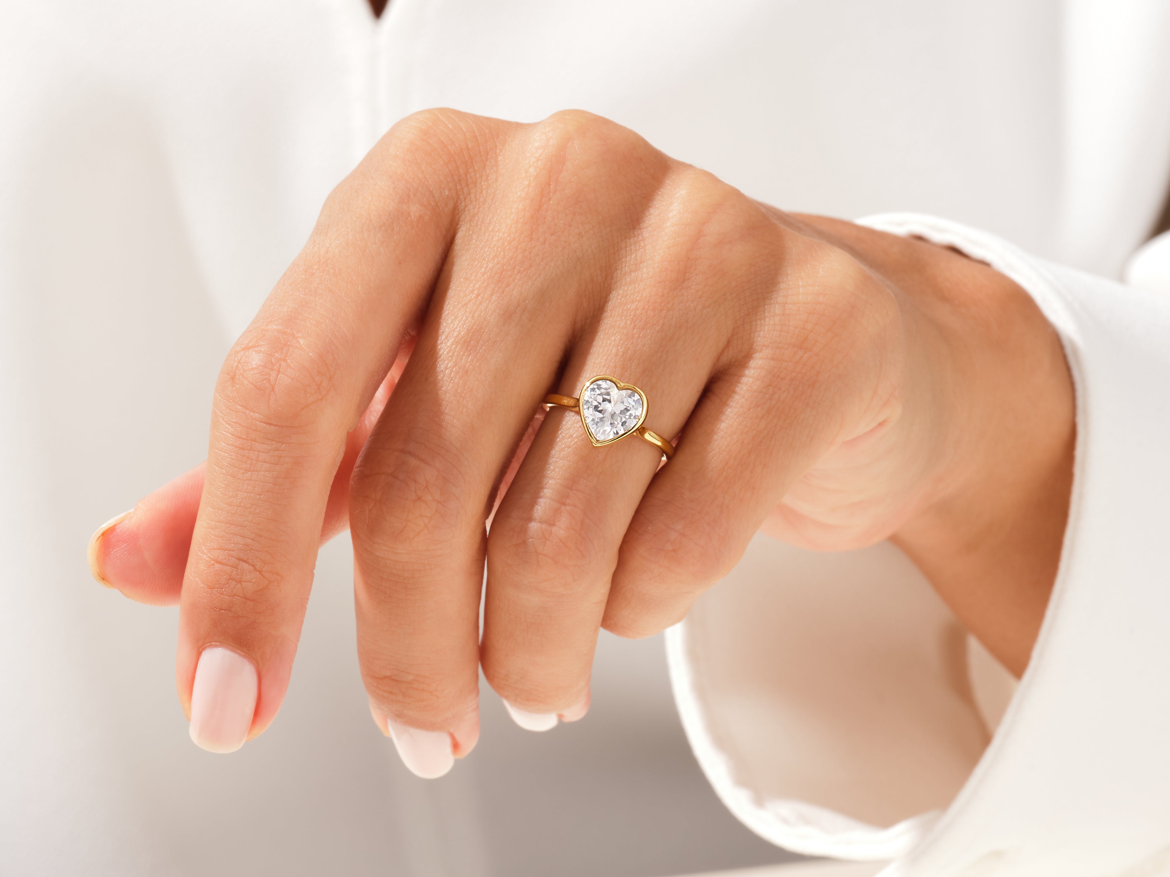 Gold heart diamond ring on a woman's finger