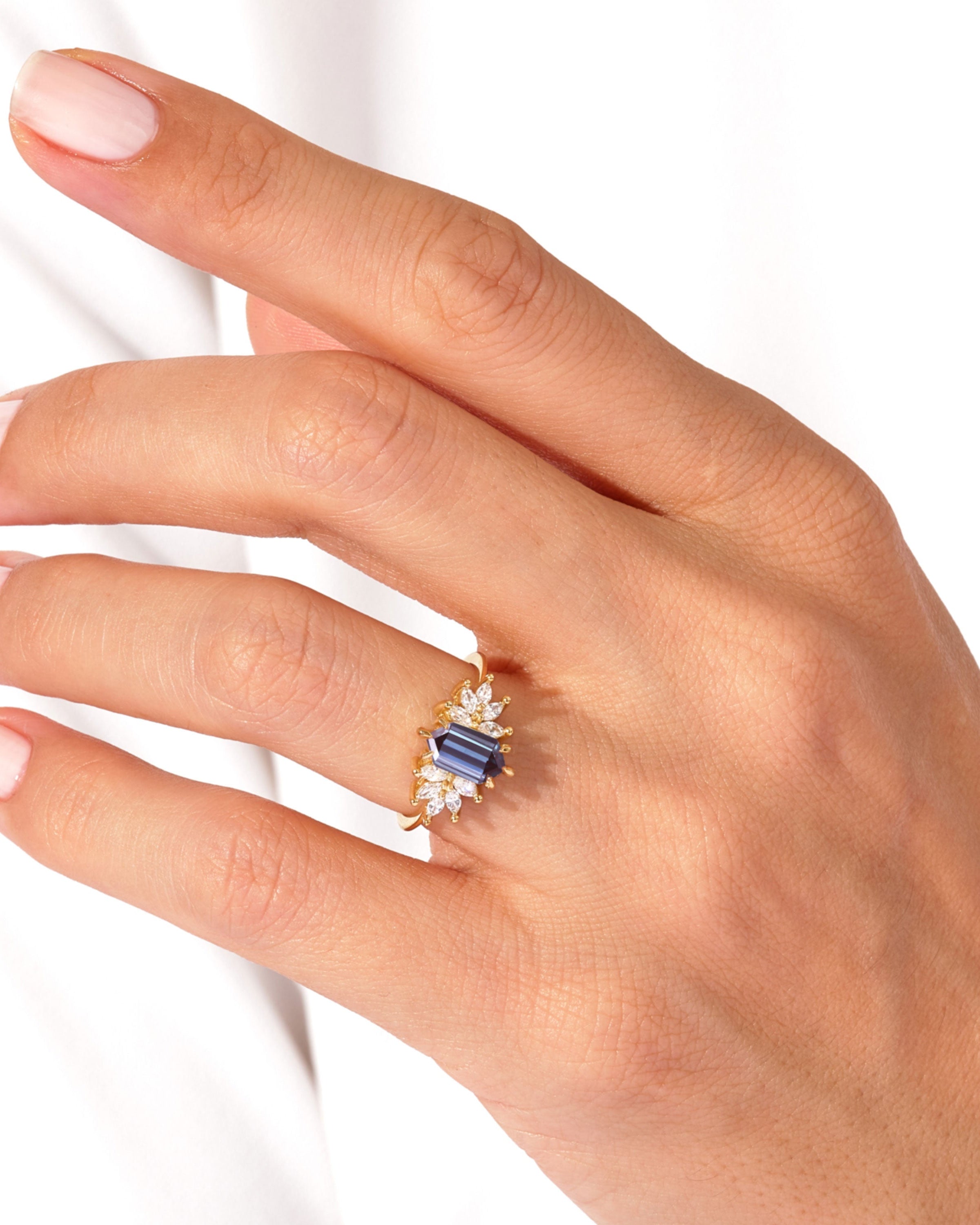 Gold ring with blue sapphire and diamonds on a hand