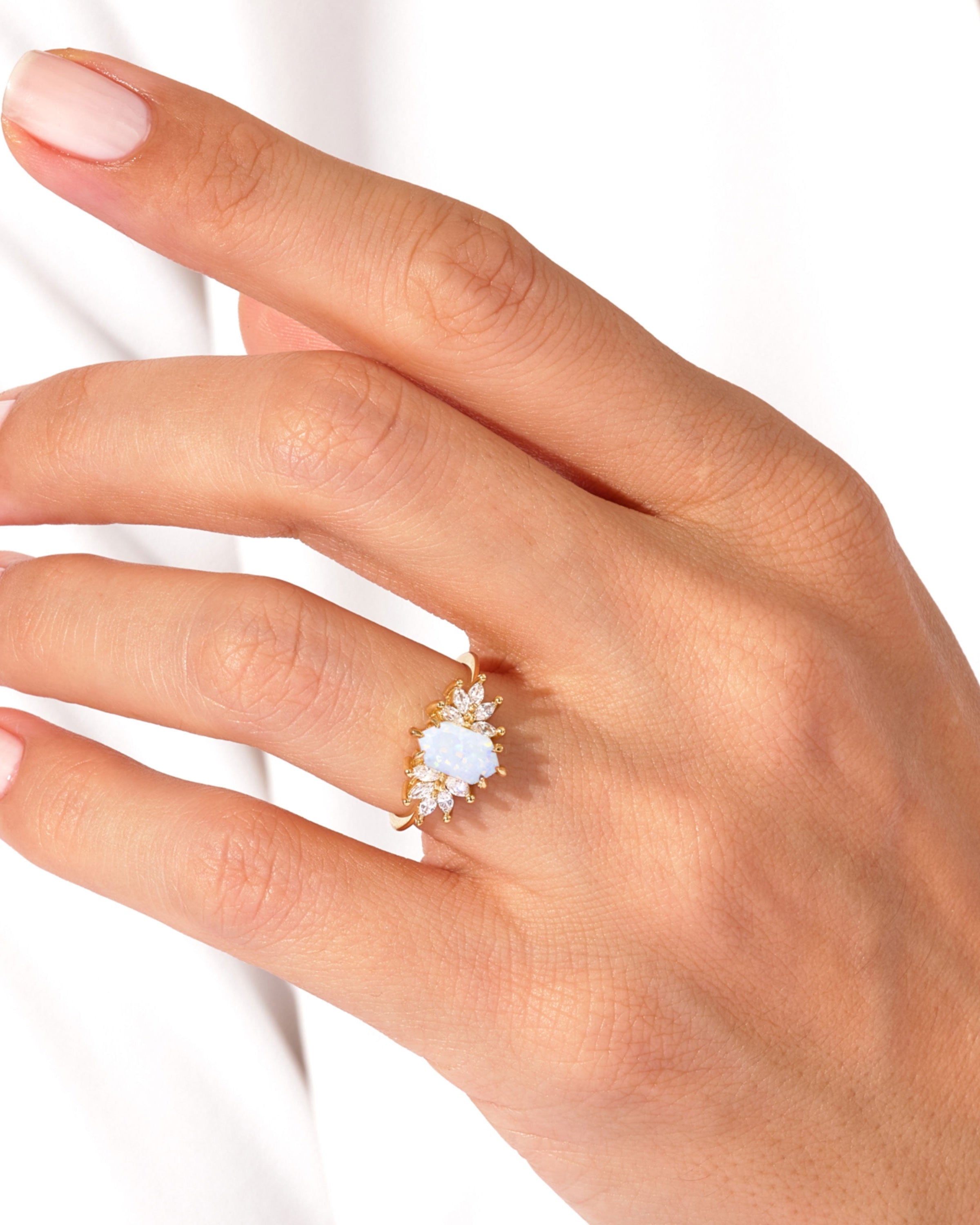 Gold opal ring with diamonds on a hand