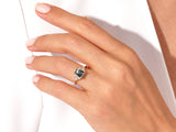 Emerald cut gemstone ring with baguette diamonds on a gold band