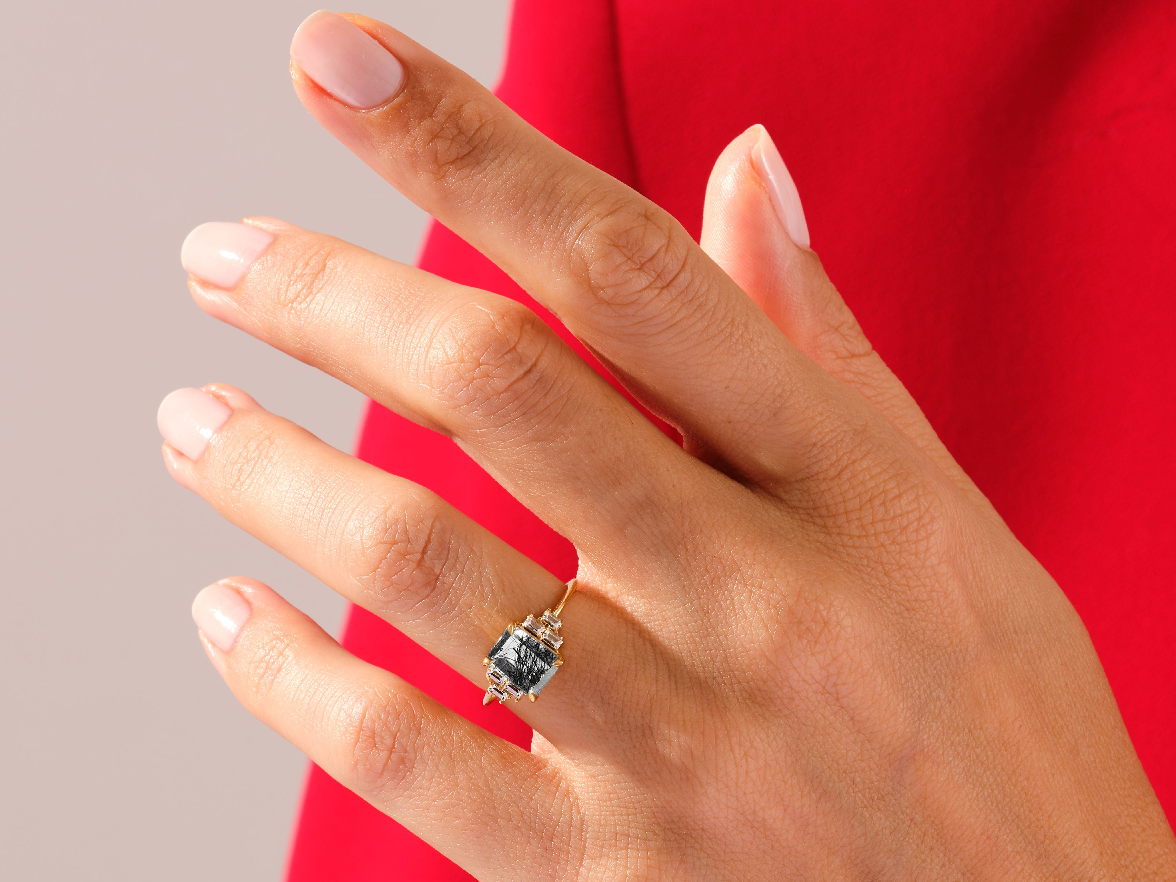Gold ring with black tourmaline gemstone and diamonds on hand