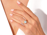 Gold opal ring with diamonds on a woman's hand