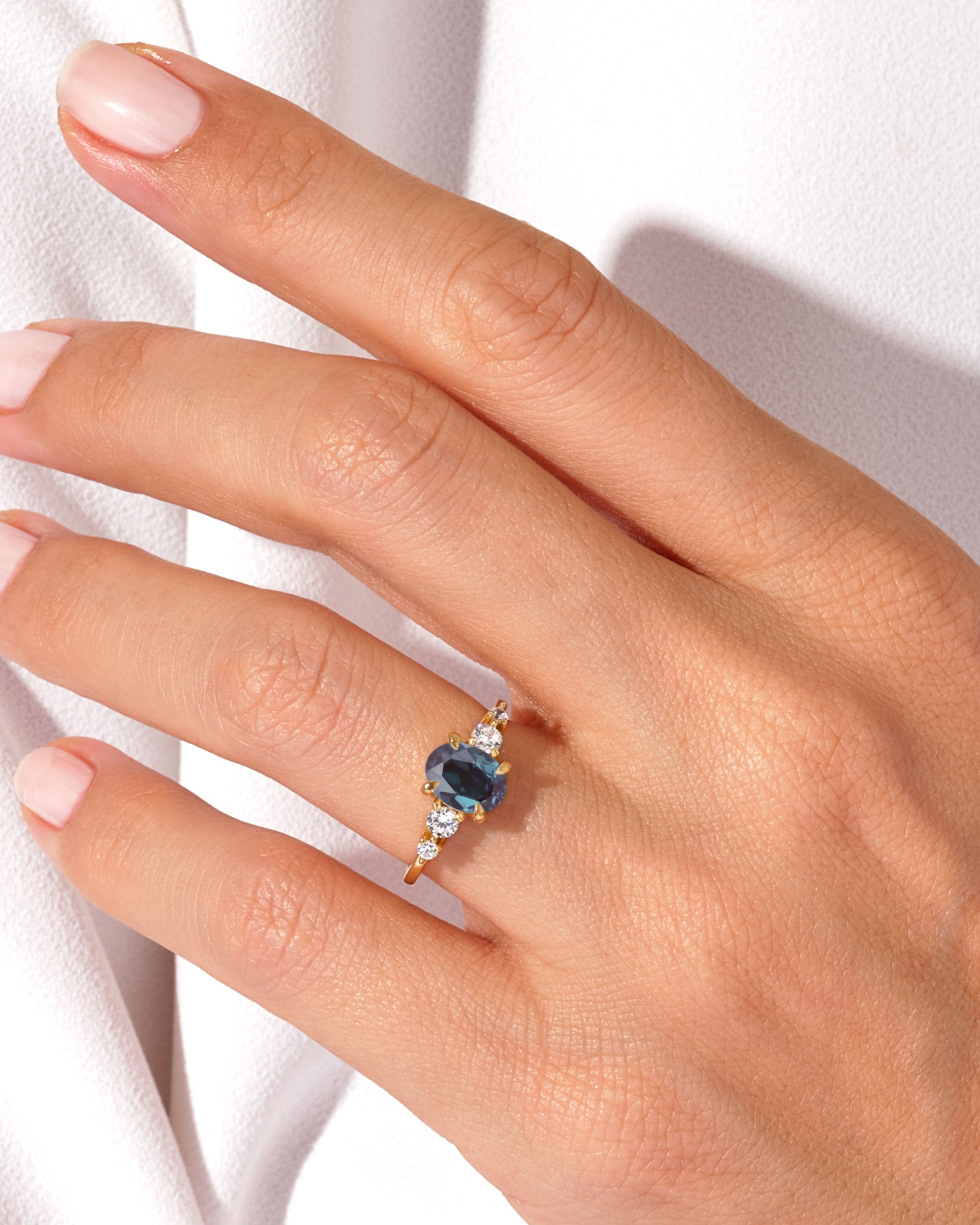 Oval sapphire and diamond engagement ring on hand