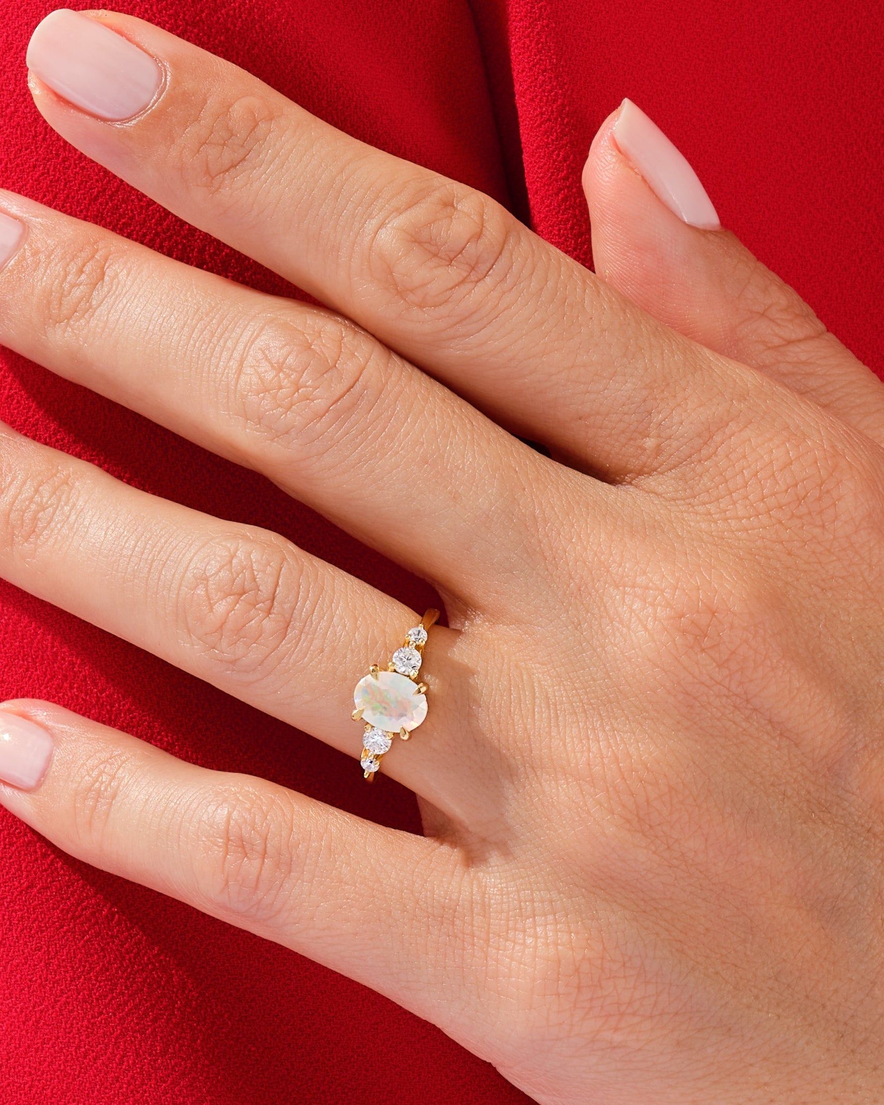 Gold opal and diamond ring on a hand
