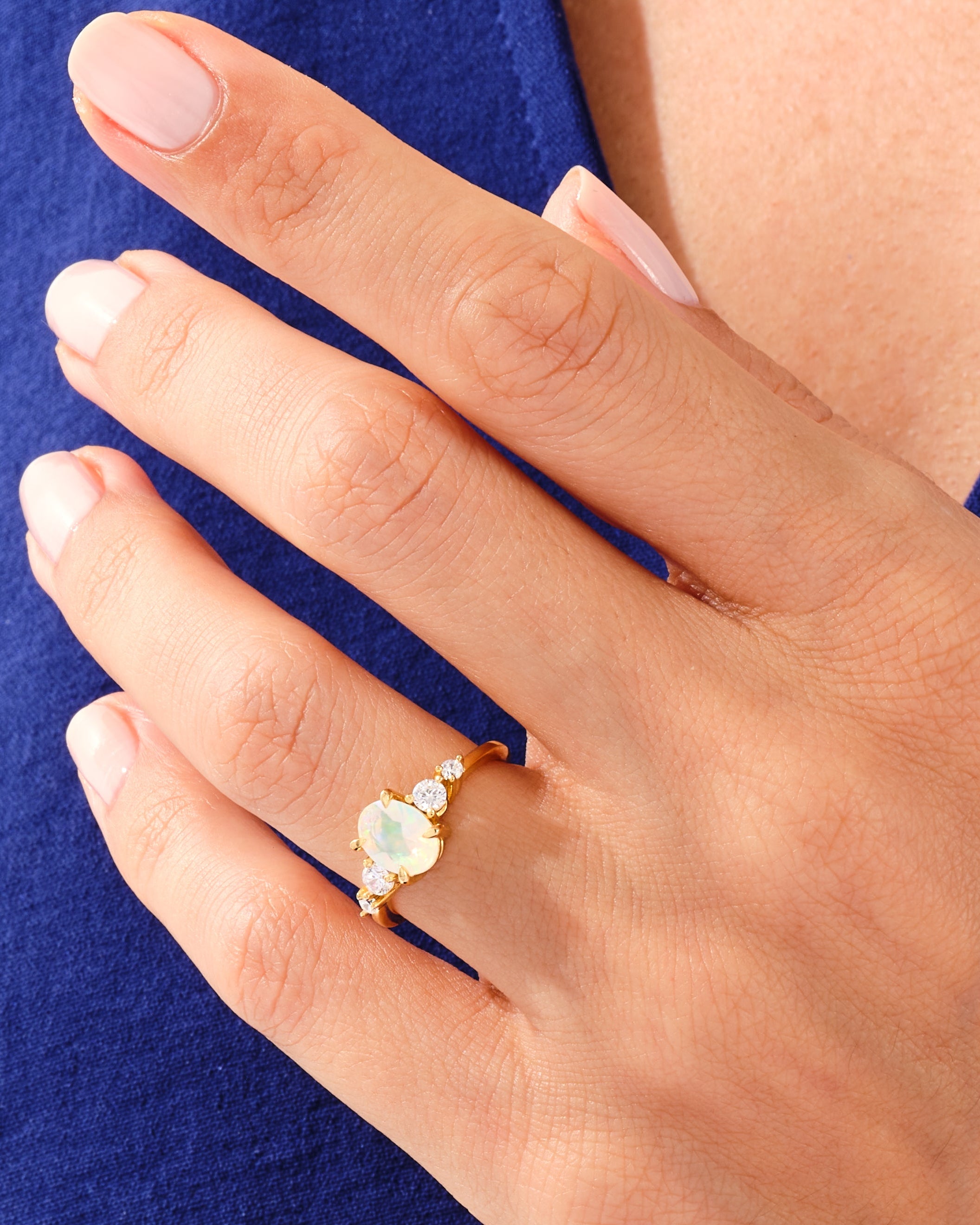 Gold opal and diamond ring on a woman's hand