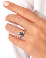 Emerald cut sapphire ring with diamonds on a gold band