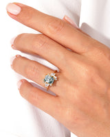 Gold ring with moss agate and diamond accents on hand