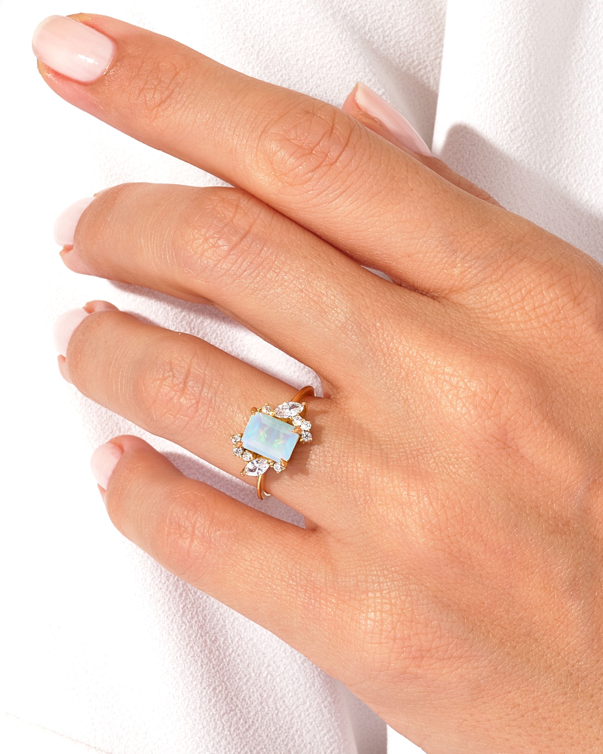 Gold ring with opal and diamonds on a woman's hand